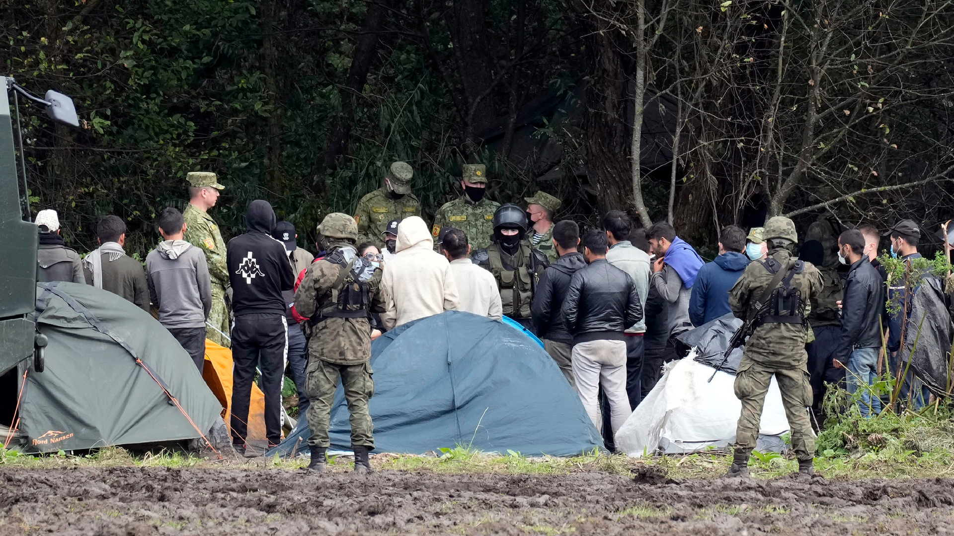 Migranten, die an der Grenze zu Belarus festsitzen, werden von polnischen Beamten umstellt. (Archivbild: 01.09.2021) | dpa