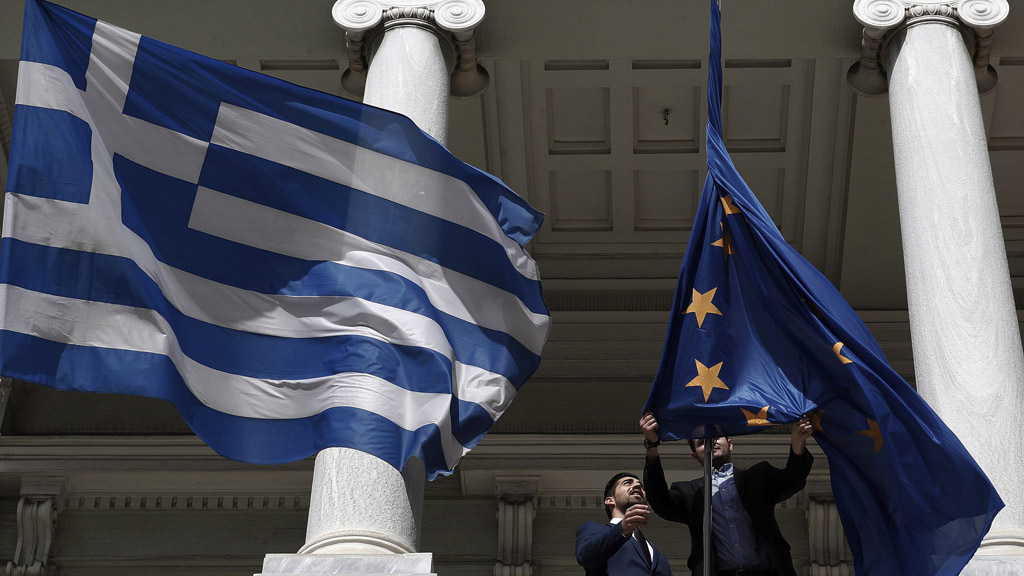 Die griechische Flagge und die EU-Flagge vor einem Ministeriumsgebäude in Athen