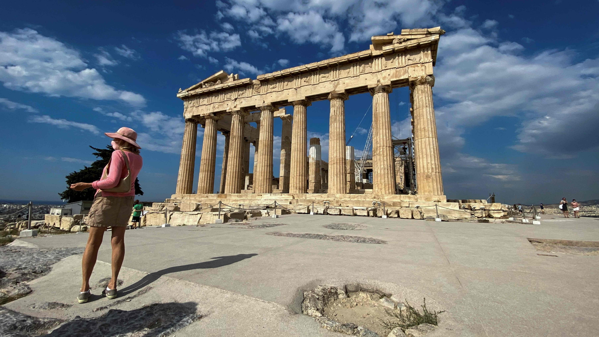 Eine Touristin steht neben der Akropolis in Griechenland | AFP