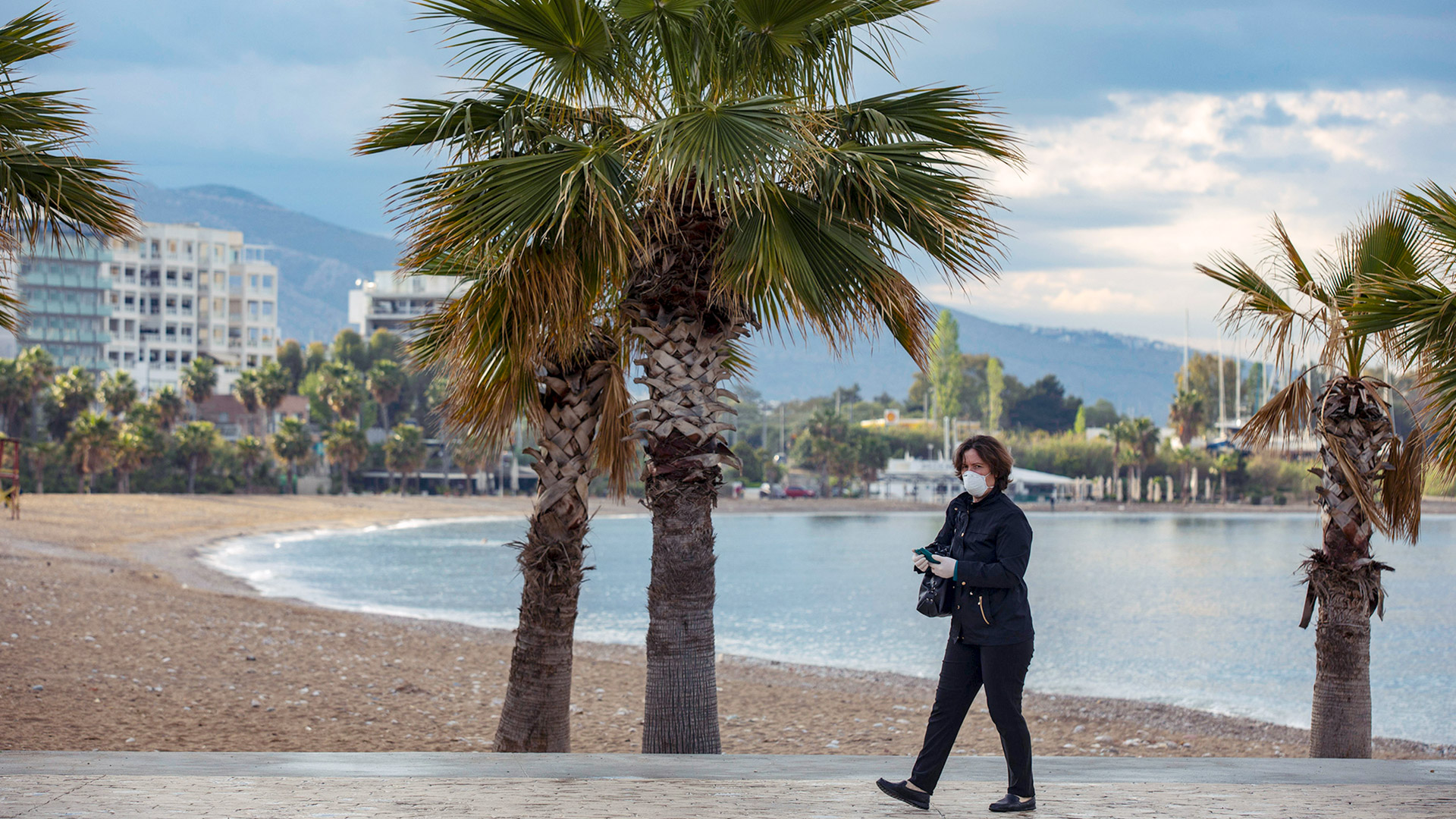 Eine Frau am leeren Strand von Alimos in Griechenland. | AP