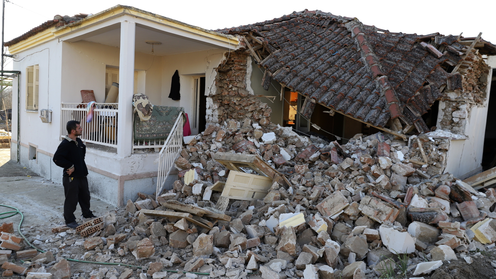 Ein Mann steht im Dorf Mesochori vor Trümmern eines Hauses, das bei einem Erdbeben beschädigt wurde. | dpa