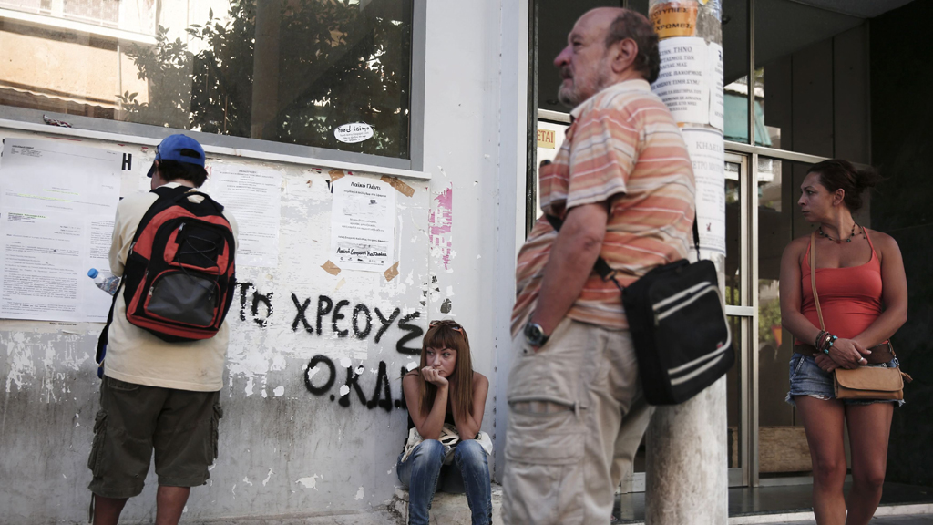 In einer Vorstadt von Athen warten griechische Arbeitslose vor derm Eingang einer Arbeitsvermittlungsagentur. Das Bild entstand am 8. August 2013.