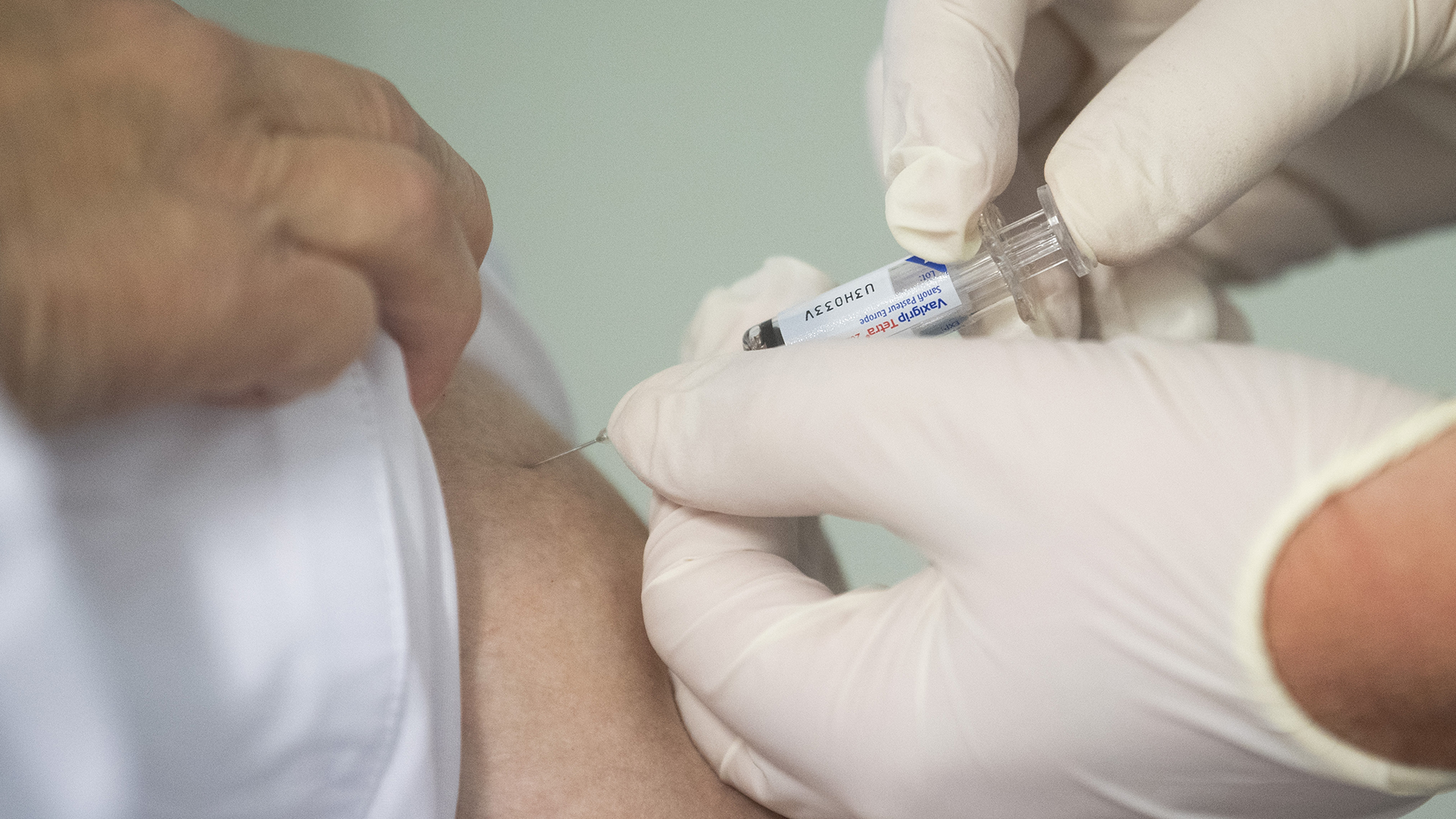 Eine Ärztin impft einen Mann mit einem Influenza-Impfstoff. | dpa