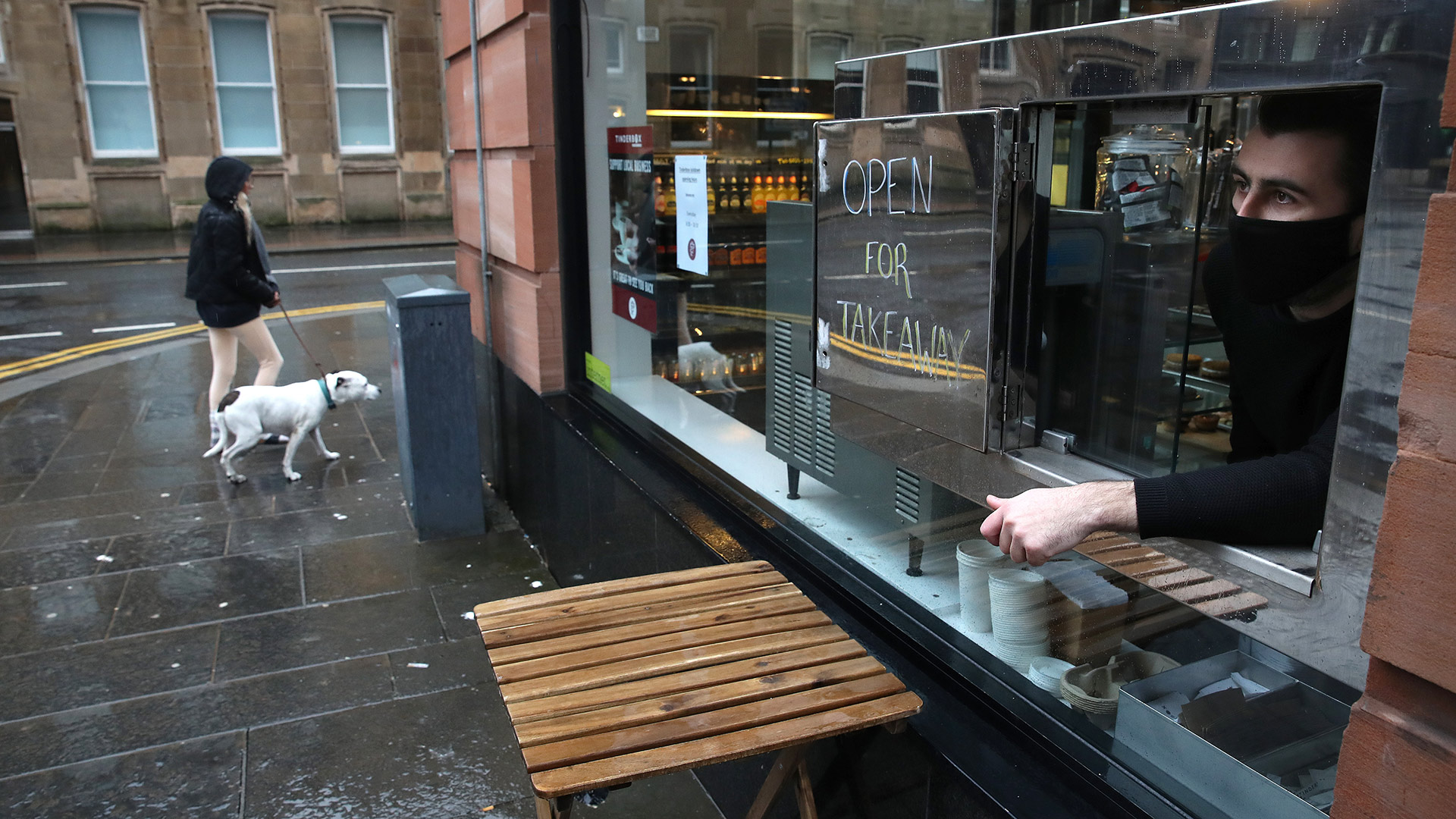 Glasgow: Frau mit Hund geht an einem Take Away vorbei