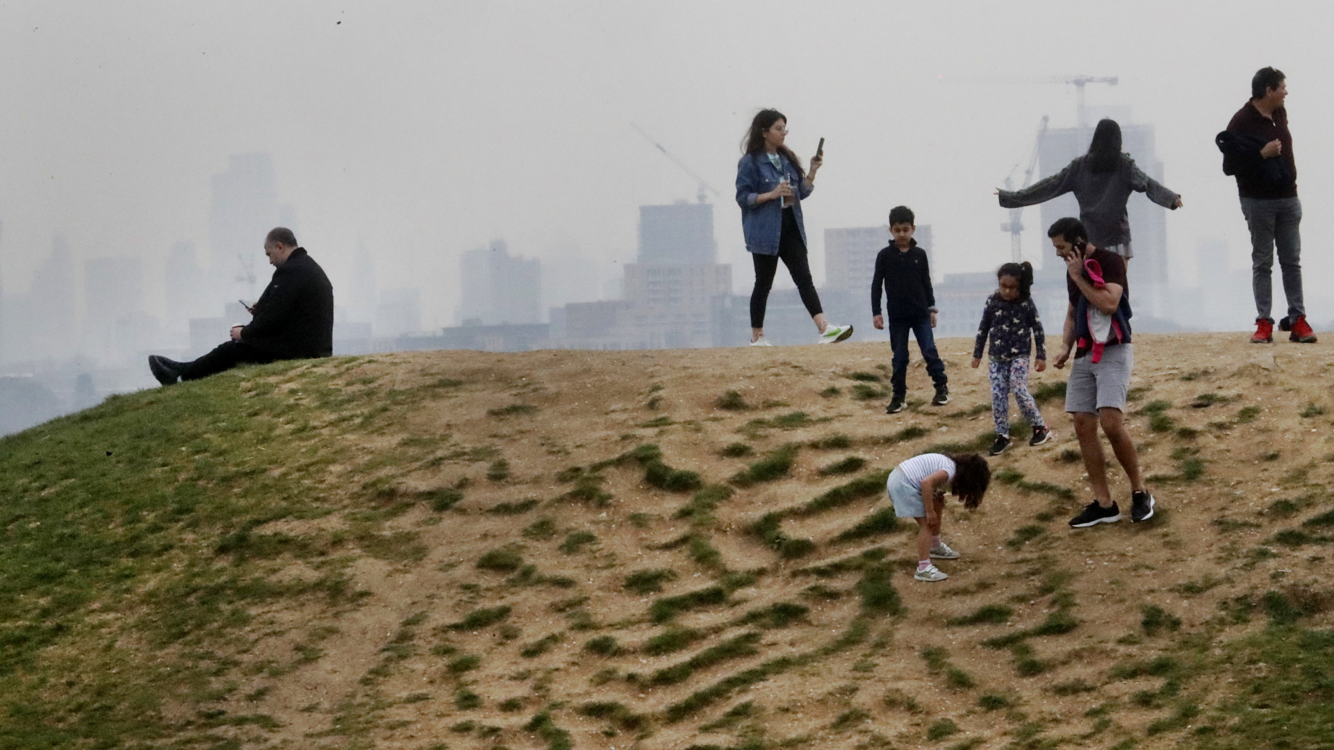 Auf einem Hügel bei Londen genießen Menschen das schöne Wetter | AP