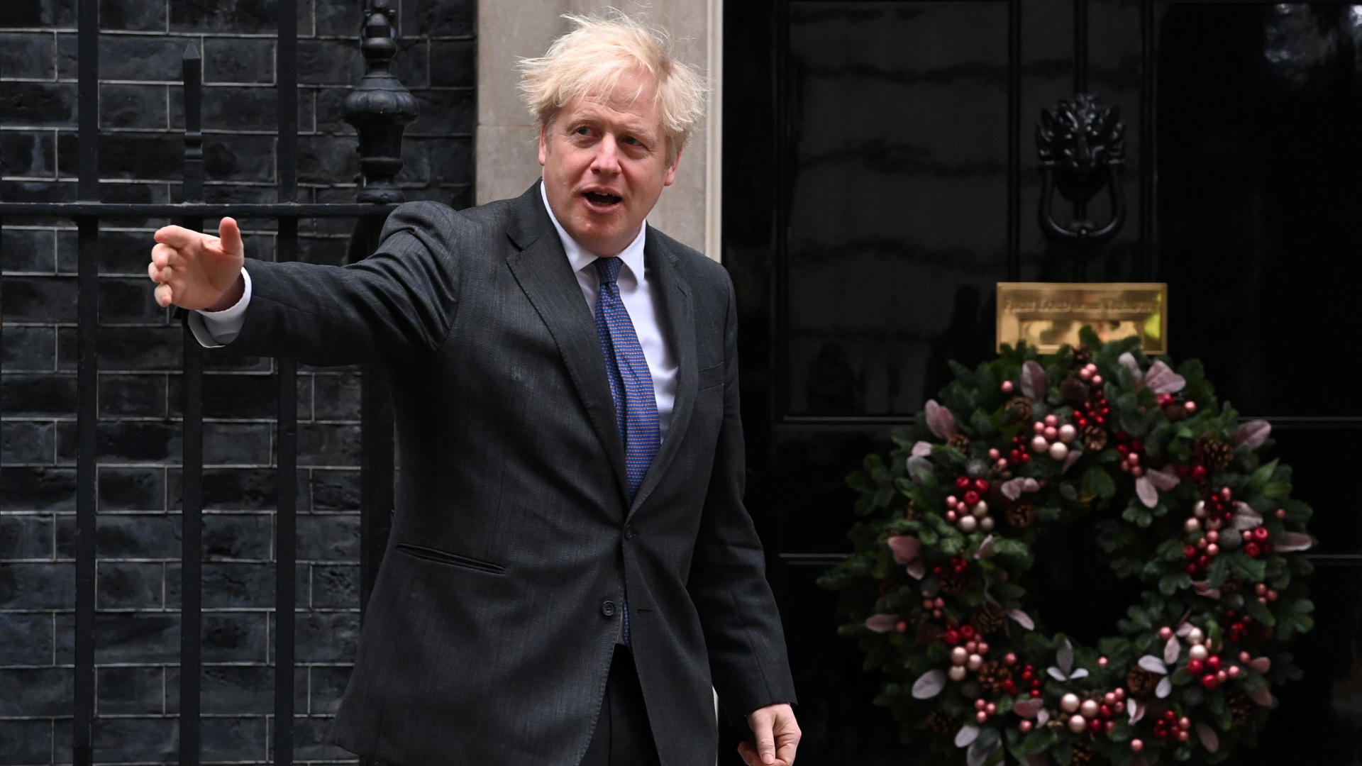 Boris Johnson steht vor der Tür von Downing Street 10, an der Mitte Dezember ein Weihnachtskranz hängt.
