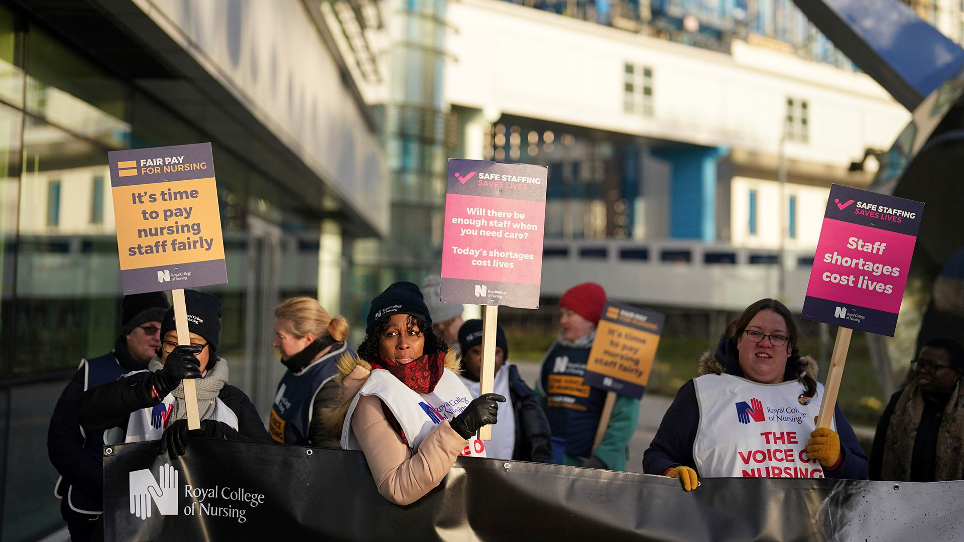 Pflegekräfte in Großbritannien halten Plakate während eines Streiks. | AP