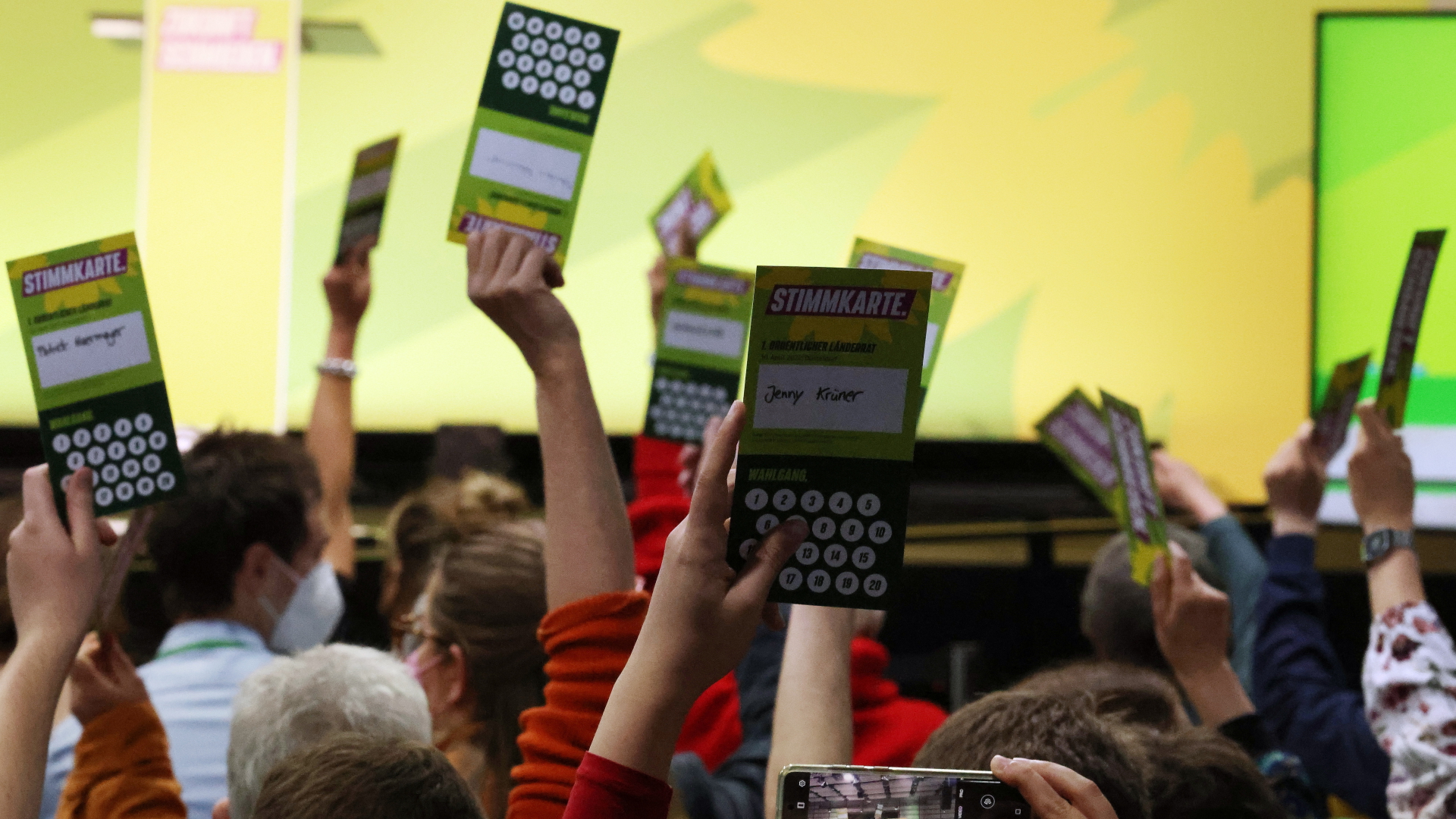 Delegierte des Grünen-Länderrats in Düsseldorf halten ihre Abstimmungskarten hoch. | dpa