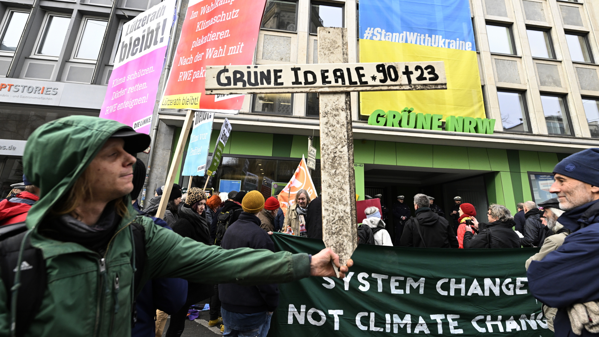 Aktivisten verschiedener Umweltinitiativen protestieren mit einem Holzkreuz vor der Grünen Parteizentrale in Nordrhein-Westfalen. | dpa