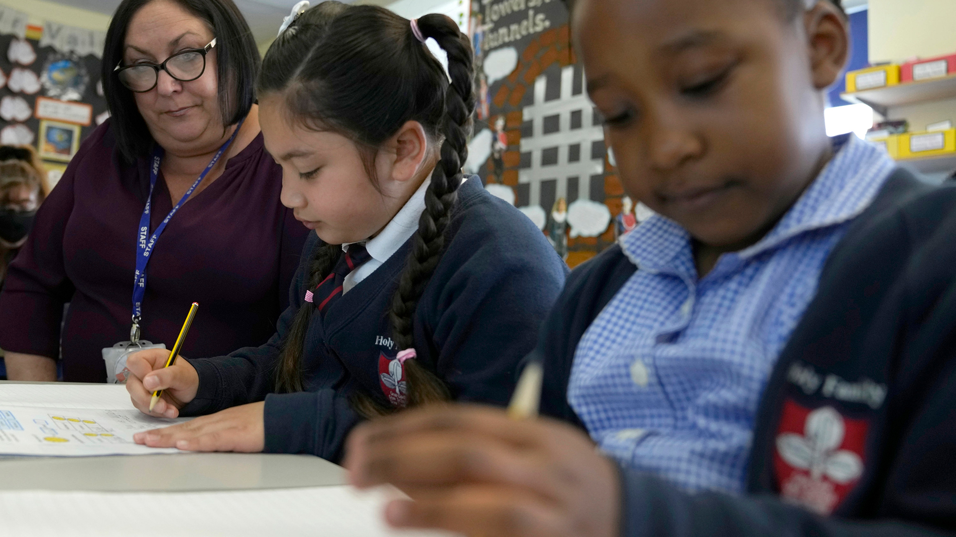 Eine Lehrerin und zwei Schülerinnen während des Unterrichts in der Holy Family Catholic Grundschule in Greenwich London. | AP