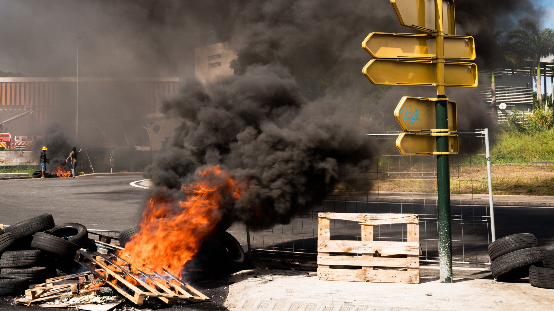 Auf einer Straße in Guadeloupe haben Demonstranten eine Blockade aus Reifen und Holz angezündet. | AFP
