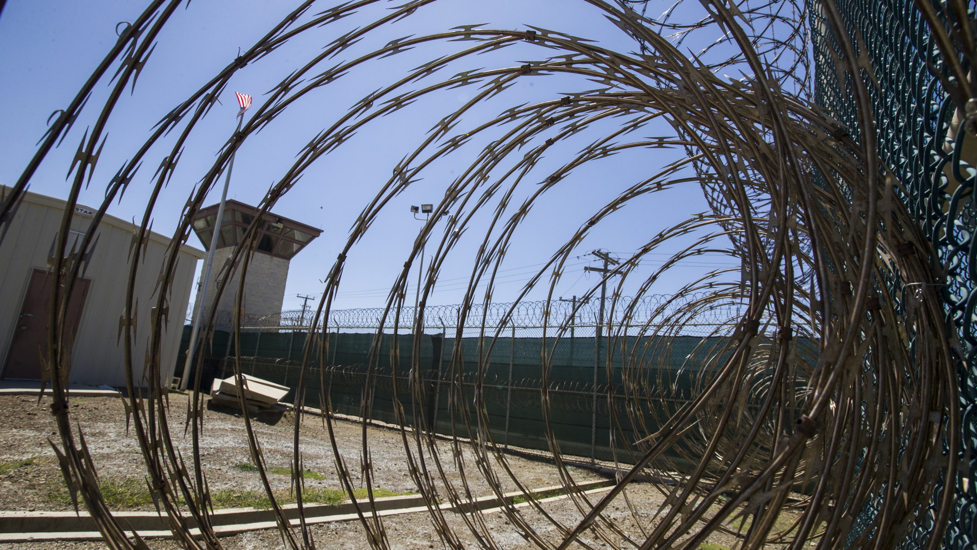 Blick durch eine Stacheldrahtrolle in den Innenhof des US-Gefangenenlager Guantanamo auf Kuba. | AP