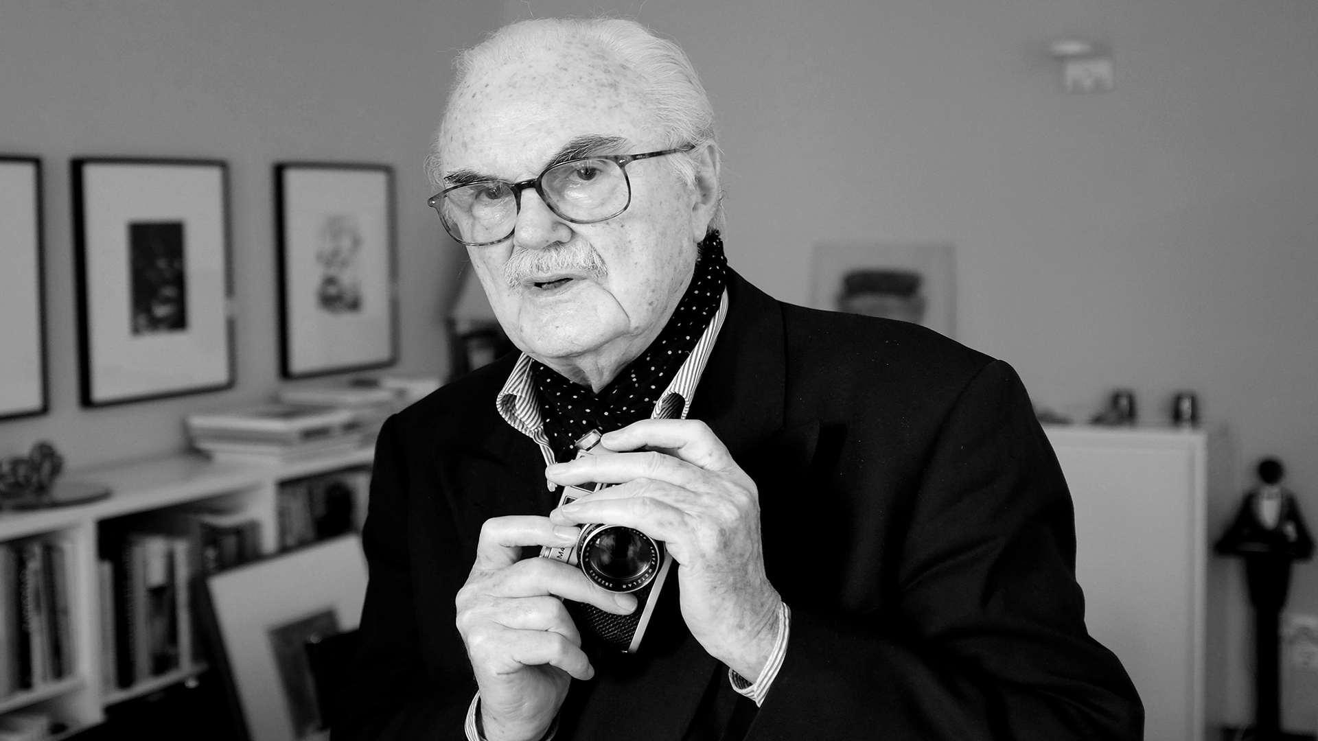 Der Fotograf F. C. Gundlach hält in seiner Wohnung eine vergoldete Leica in den Händen. | dpa
