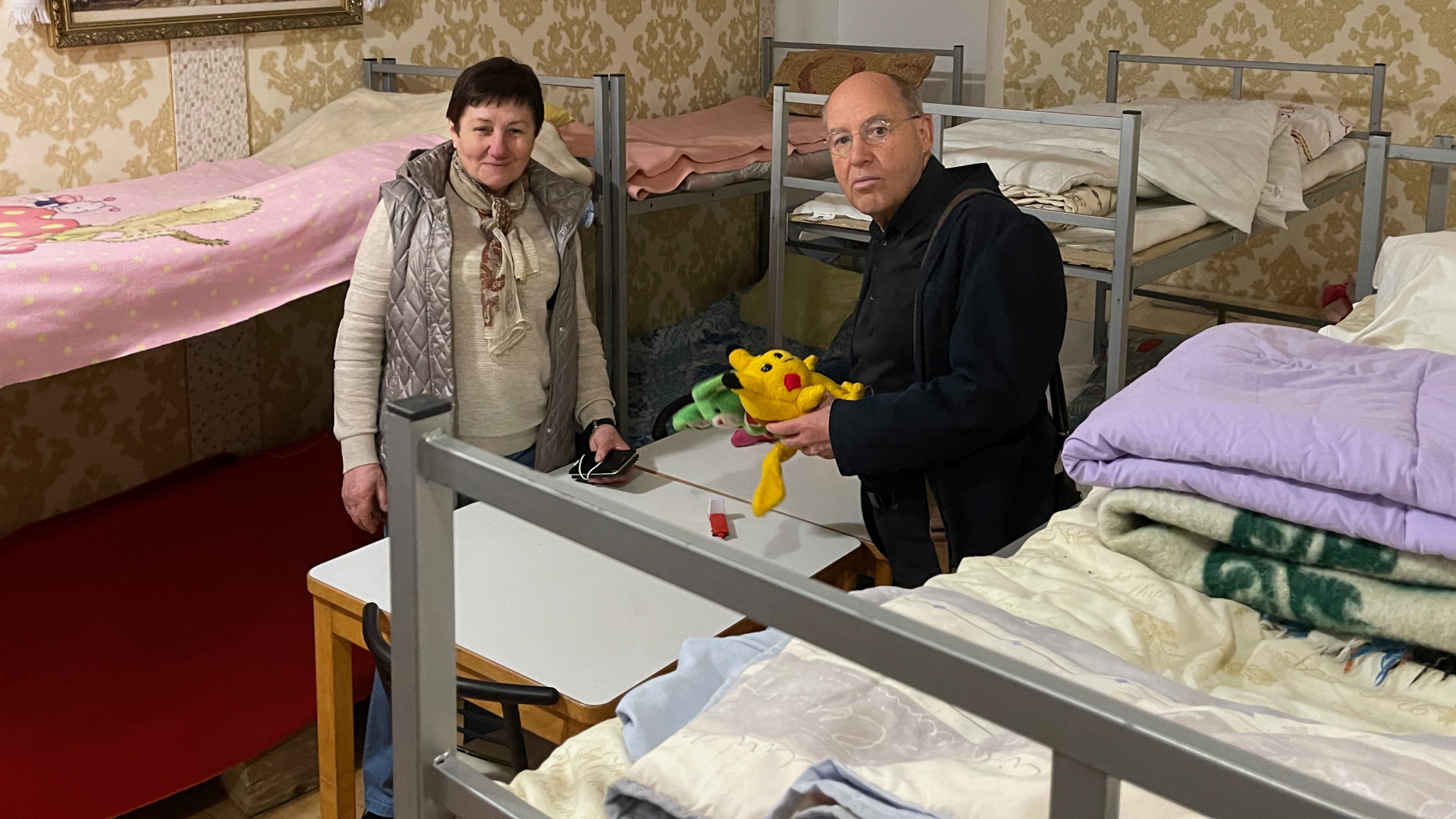 Gregor Gysi steht in einer Notunterkunft in Lwiw neben einer Frau, die vor dem Krieg geflohen ist. | dpa