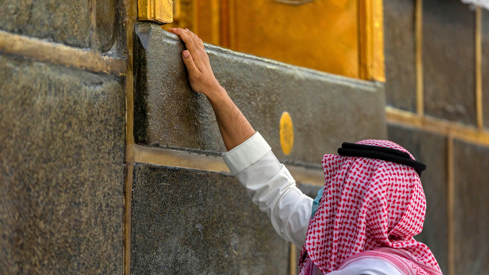 Ein Pilger berührt die Kaaba, das quaderförmige Gebilde im Innenhof der Heiligen Moschee, in dessen Richtung sich Gläubige beim Beten wenden | dpa