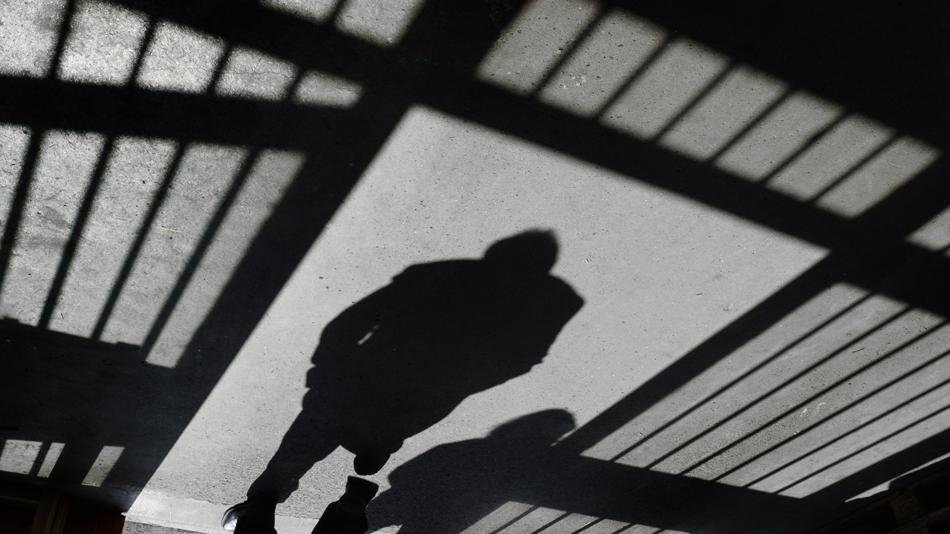 Der Schattenriss eines Mannes ist in einer Justizvollzugsanstalt in einer Tür zu sehen. | picture alliance / Felix Kästle