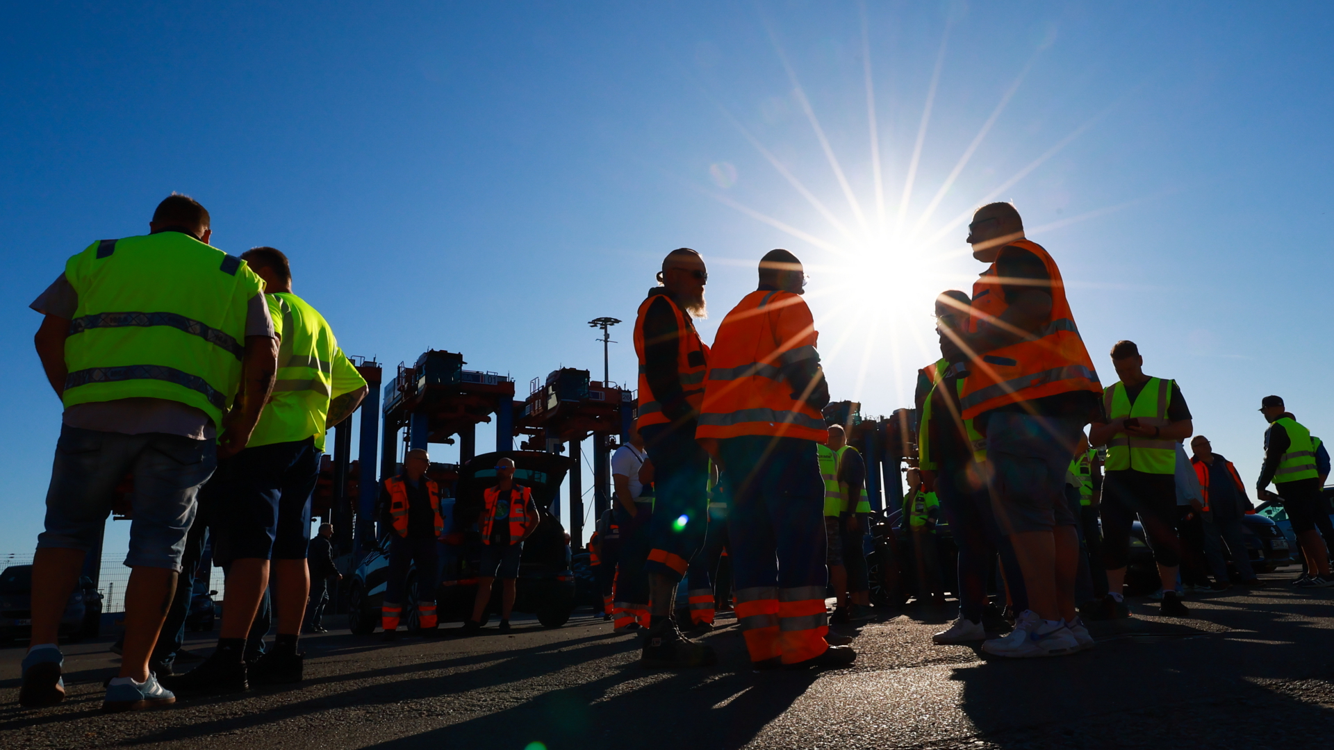 Hafenmitarbeiter stehen während eines Warnstreiks bei strahlendem Sonnenschein am Hamburger Hafen. | dpa