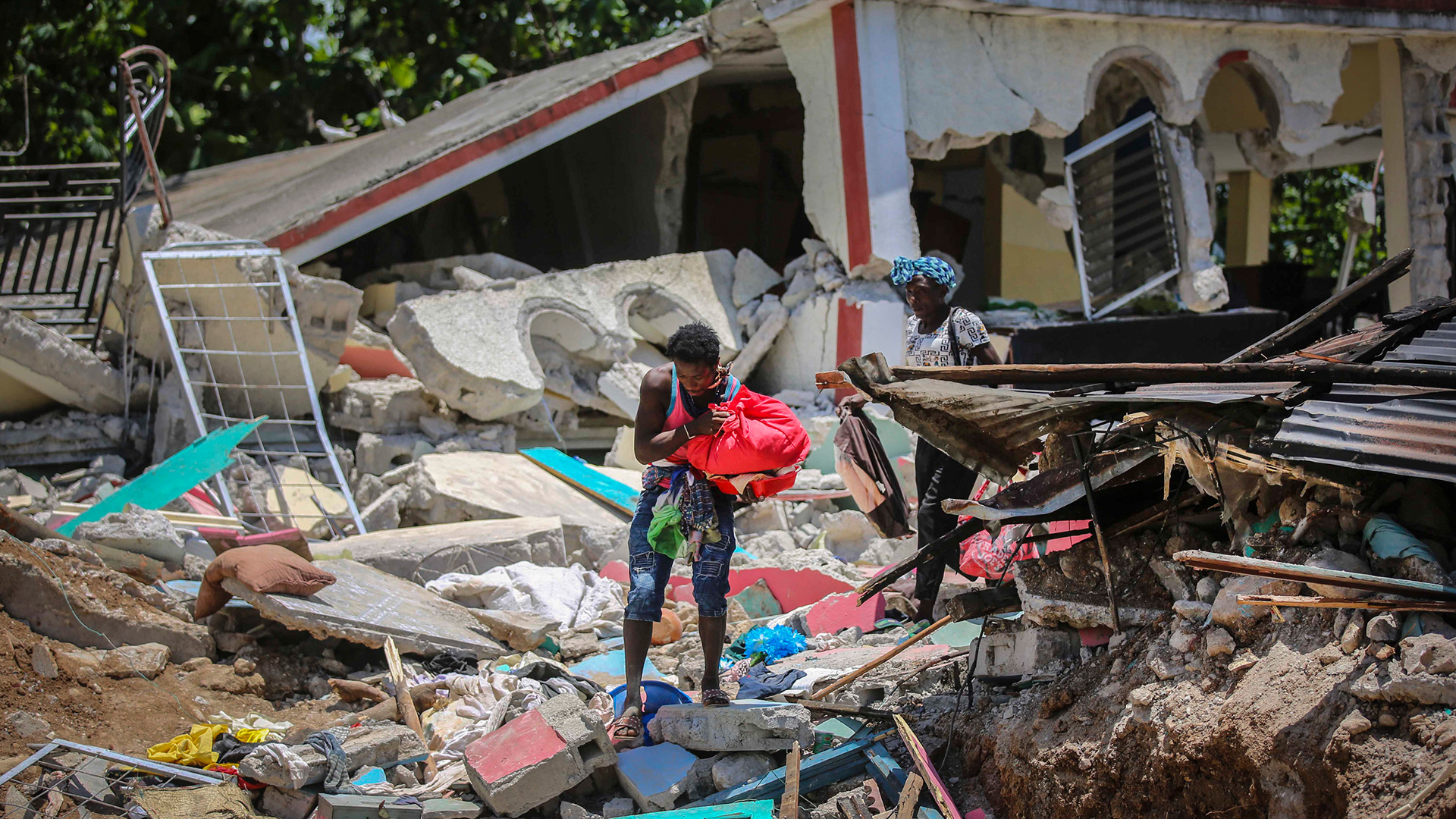 Einheimische bergen ihr Hab und Gut aus ihren zerstörten Häusern in Camp-Perrin (Haiti). | AP