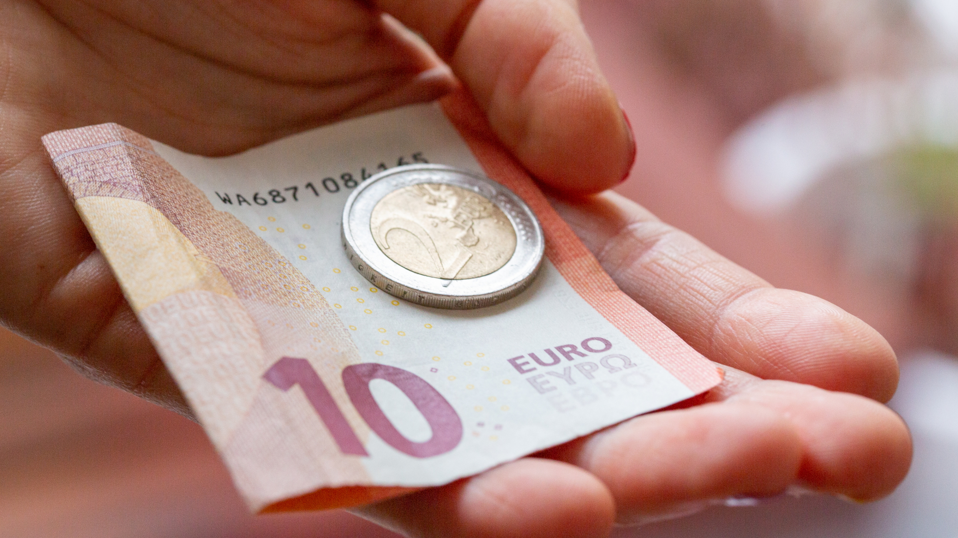 Eine Person hält 12 Euro in der Hand. | dpa