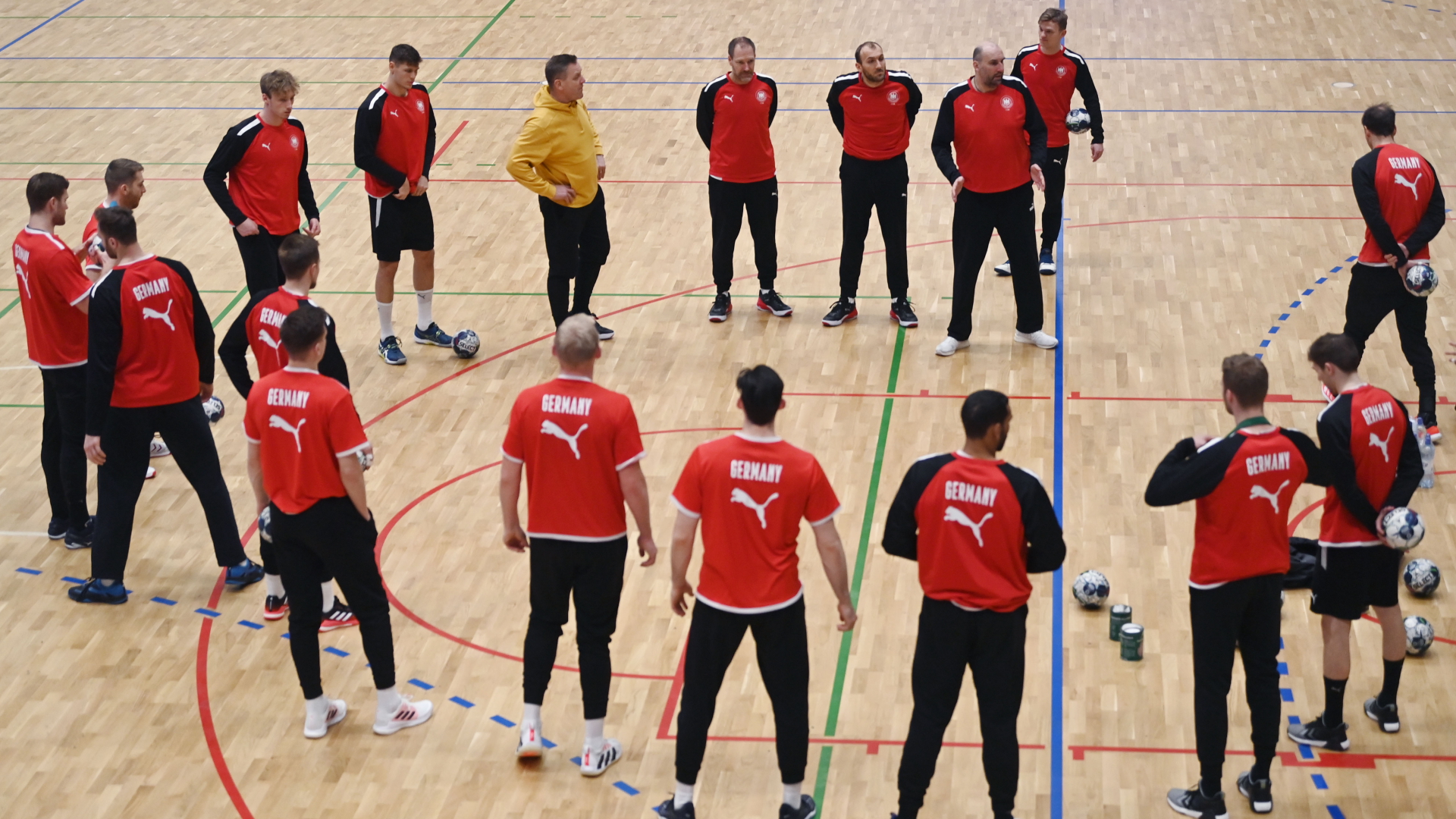 Die deutschen Handball-Nationalmannschaft steht zu Beginn eines Trainings zusammen auf dem Spielfeld. | dpa