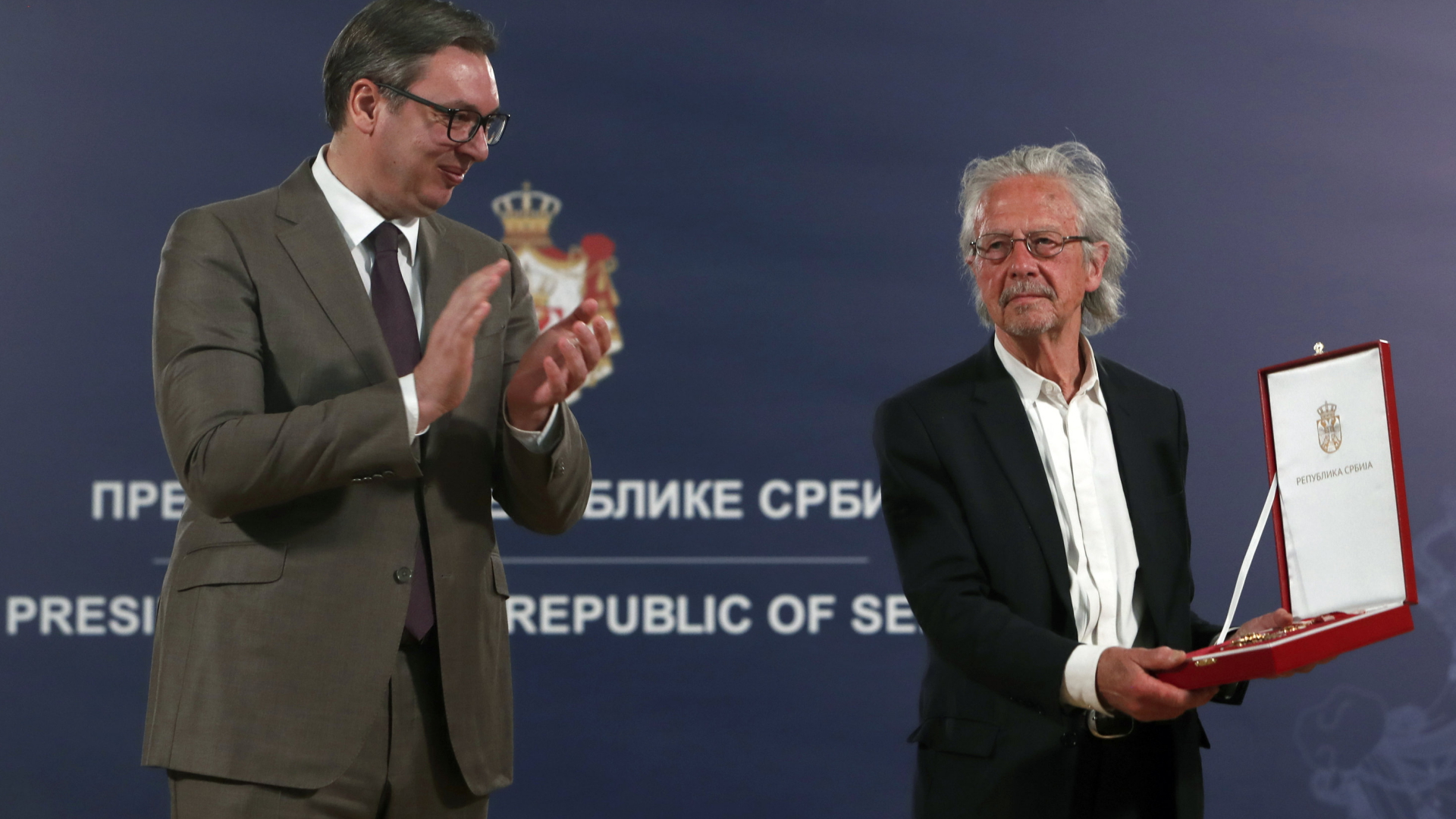 Der serbische Präsident Aleksandar Vucic (links) applaudiert, nachdem er dem Schriftsteller Peter Handke im Mai 2021 die Auszeichnung des Kardjordje-Sterns überreicht hat. | AP