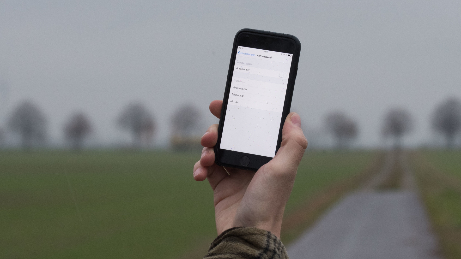 Ein Mann lässt in der Region Hannover auf einem Feldweg sein Smartphone nach Netzbetreibern suchen. | dpa