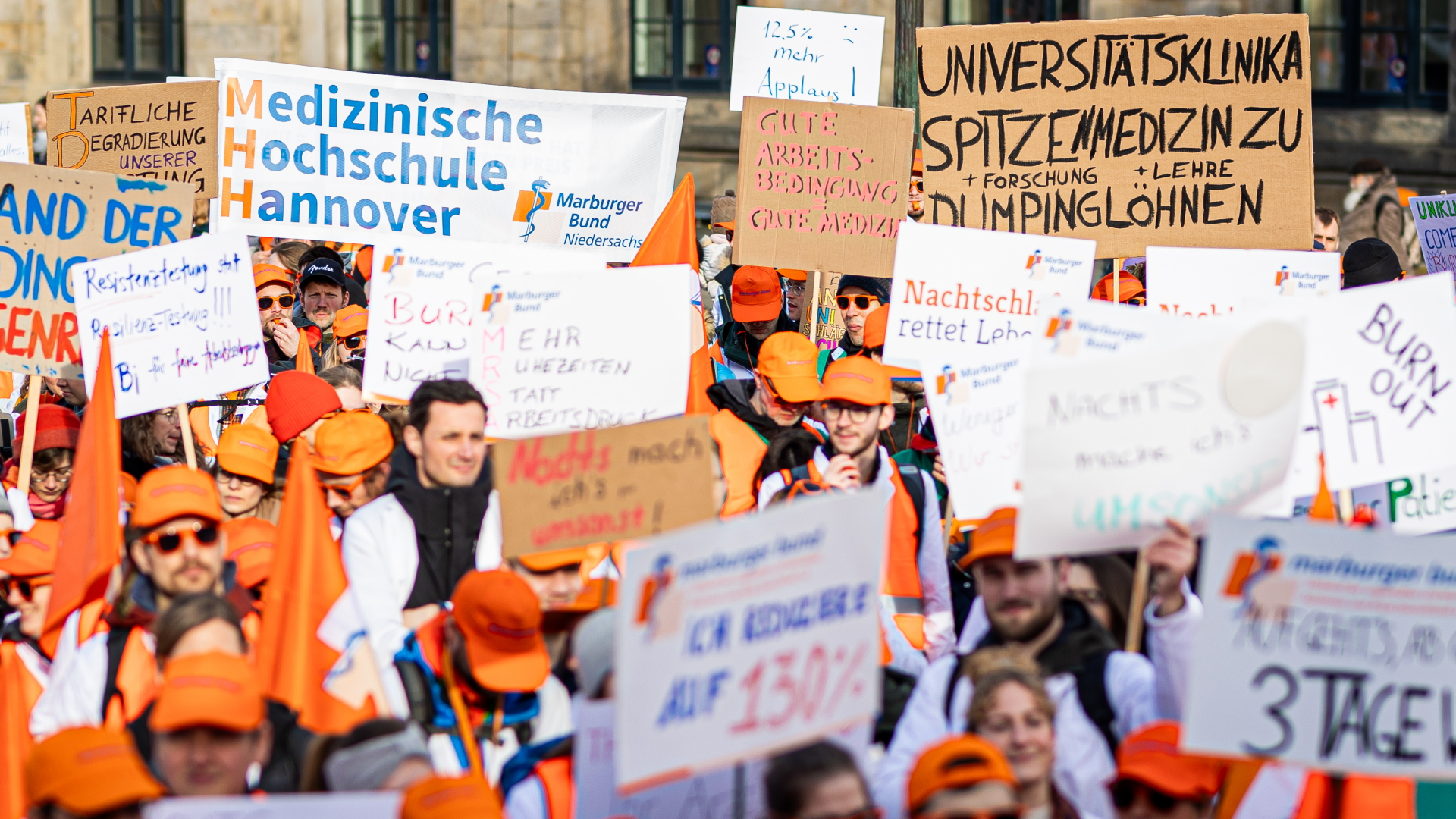 Menschen nehmen an einer Demonstration von Uniklinik-Ärzten auf dem Opernplatz in Hannover teil.