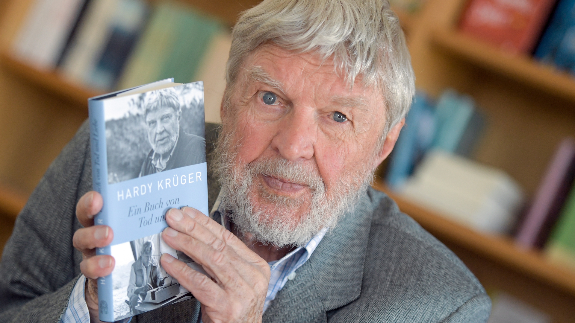 Der Schauspieler Hardy Krüger hält im Verlag Hoffmann und Campe sein Buch mit dem Titel "Ein Buch von Tod und Liebe" in den Händen. | dpa