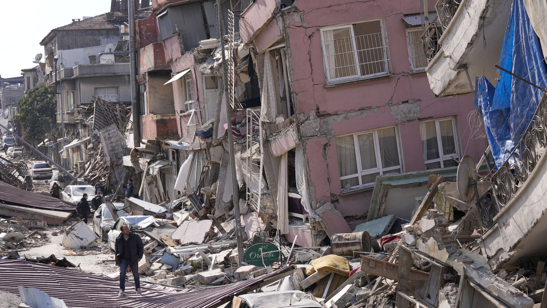 Ein Mann läuft an vom Erdbeben zerstörten Häusern in Hatay (Türkei) vorbei.