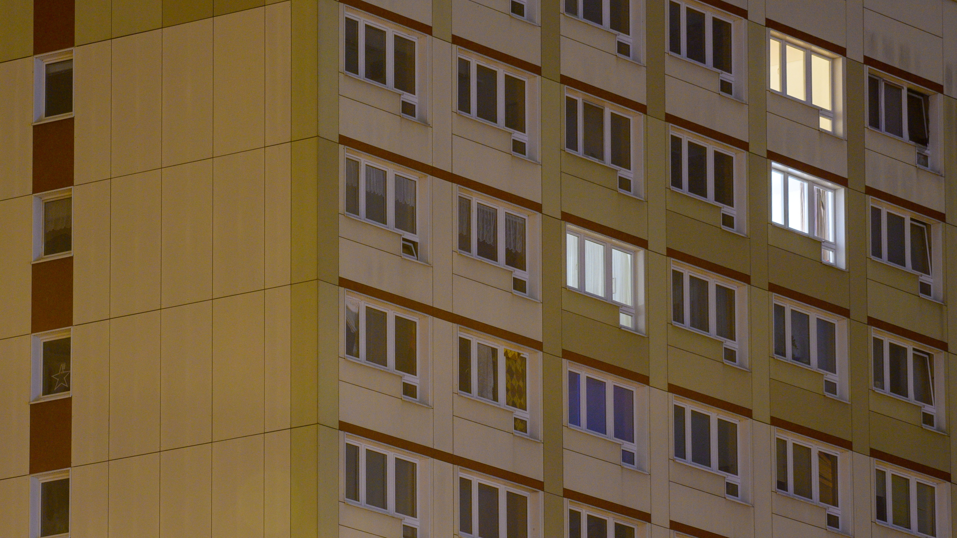 Vereinzelt brennen Lichter in den Fenstern eines Hochhauses. | dpa