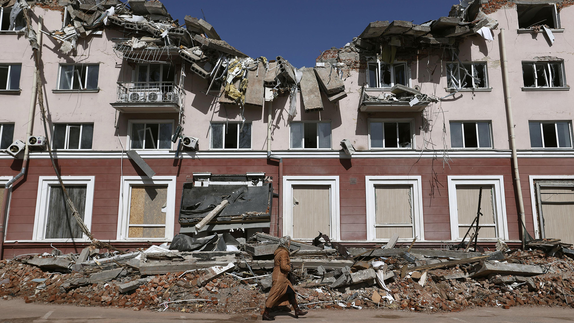 Eine Frau geht an einem Hotel in Tschernihiw (Ukraine) vorbei, das bei russischen Angriffen zerstört wurde. | dpa