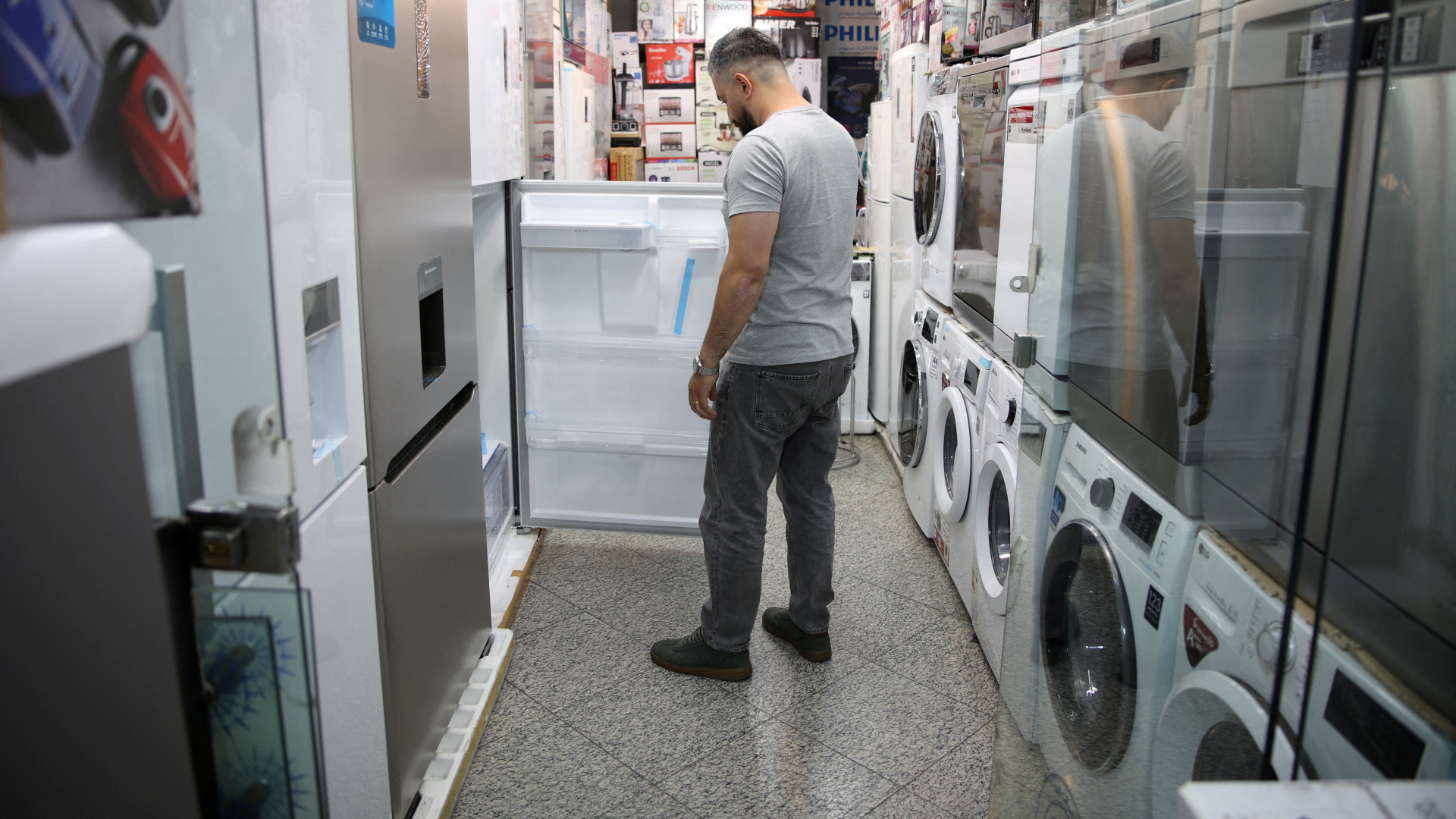 Ein Man öffnet einen Kühlschrank in einem Laden für Haushaltsgeräte | via REUTERS