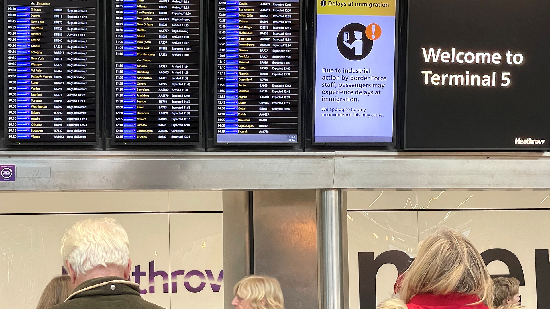 Menschen stehen vor einer Anzeigetafel im Flughafen Heathrow, auf der ein Hinweis auf Streiks beim Flughafenpersonal steht. | REUTERS