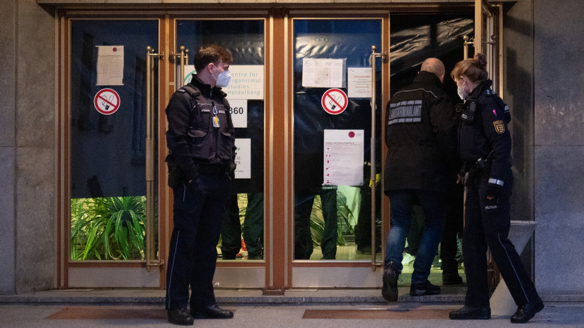 Polizeibeamte betreten ein Gebäude auf dem Campus der Universität Heidelberg.