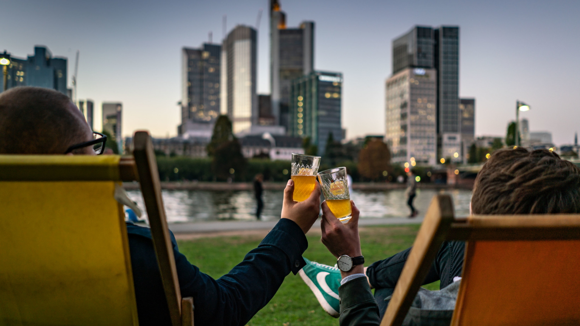 Zwei Angestellte in Frankfurt trinken am Mainufer