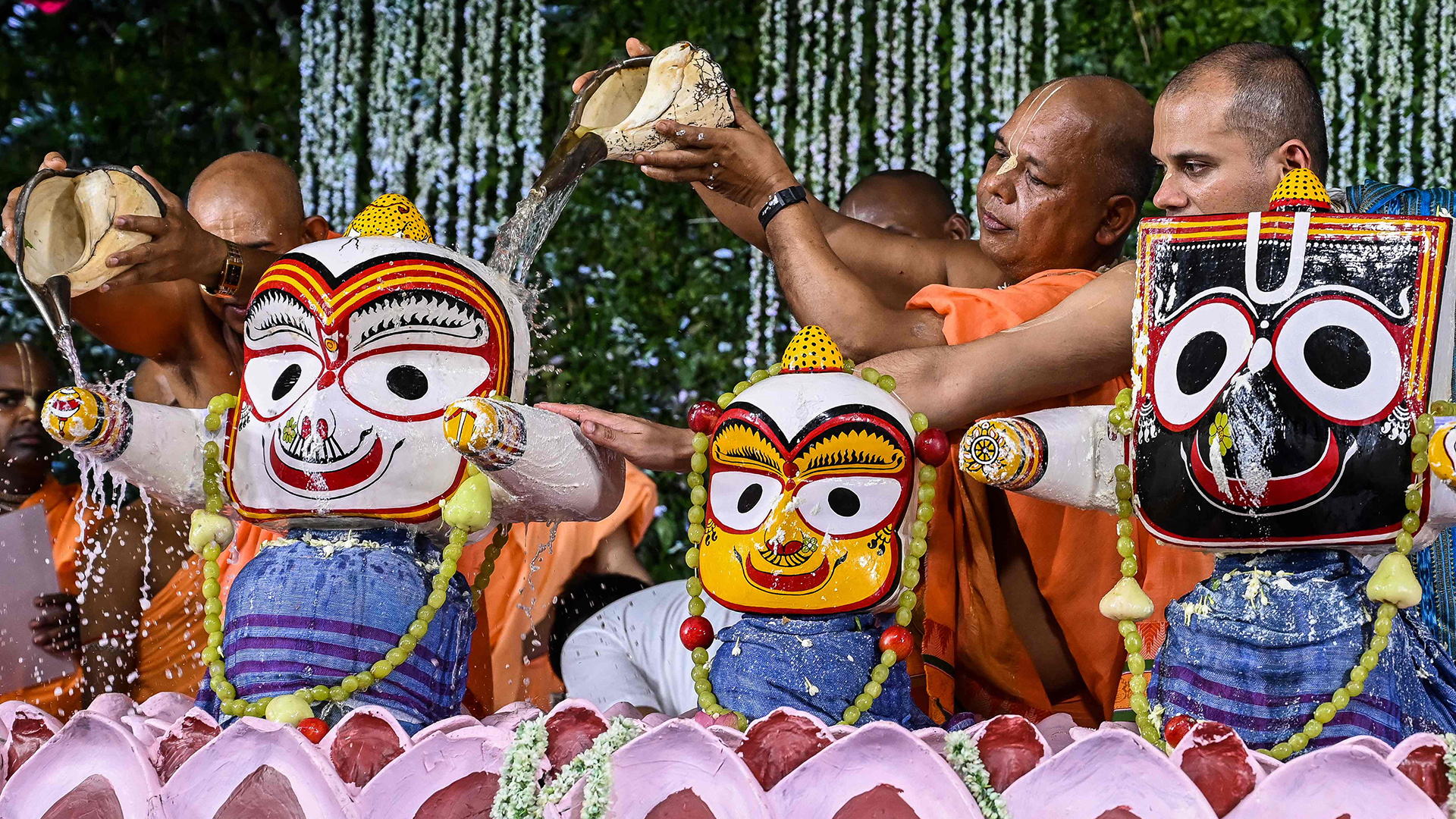 Hinduistische Mönche führen anlässlich des Festes "Snana Yatra" im indischen Kalkutta ein Ritual durch. Dabei werden Hindu-Gottheiten in Milch gebadet. | AFP
