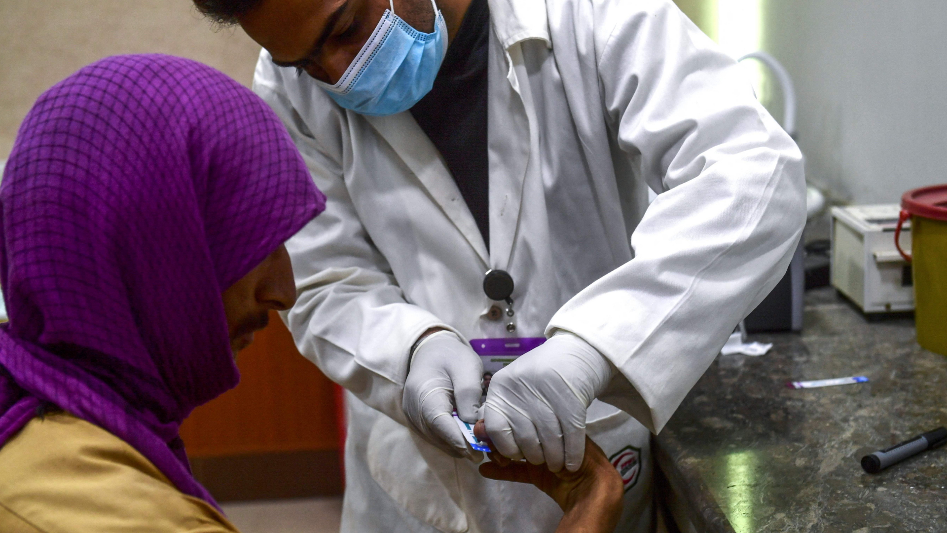Ein Mediziner nimmt einem Mann eine Blutprobe für einen HIV-Test | AFP