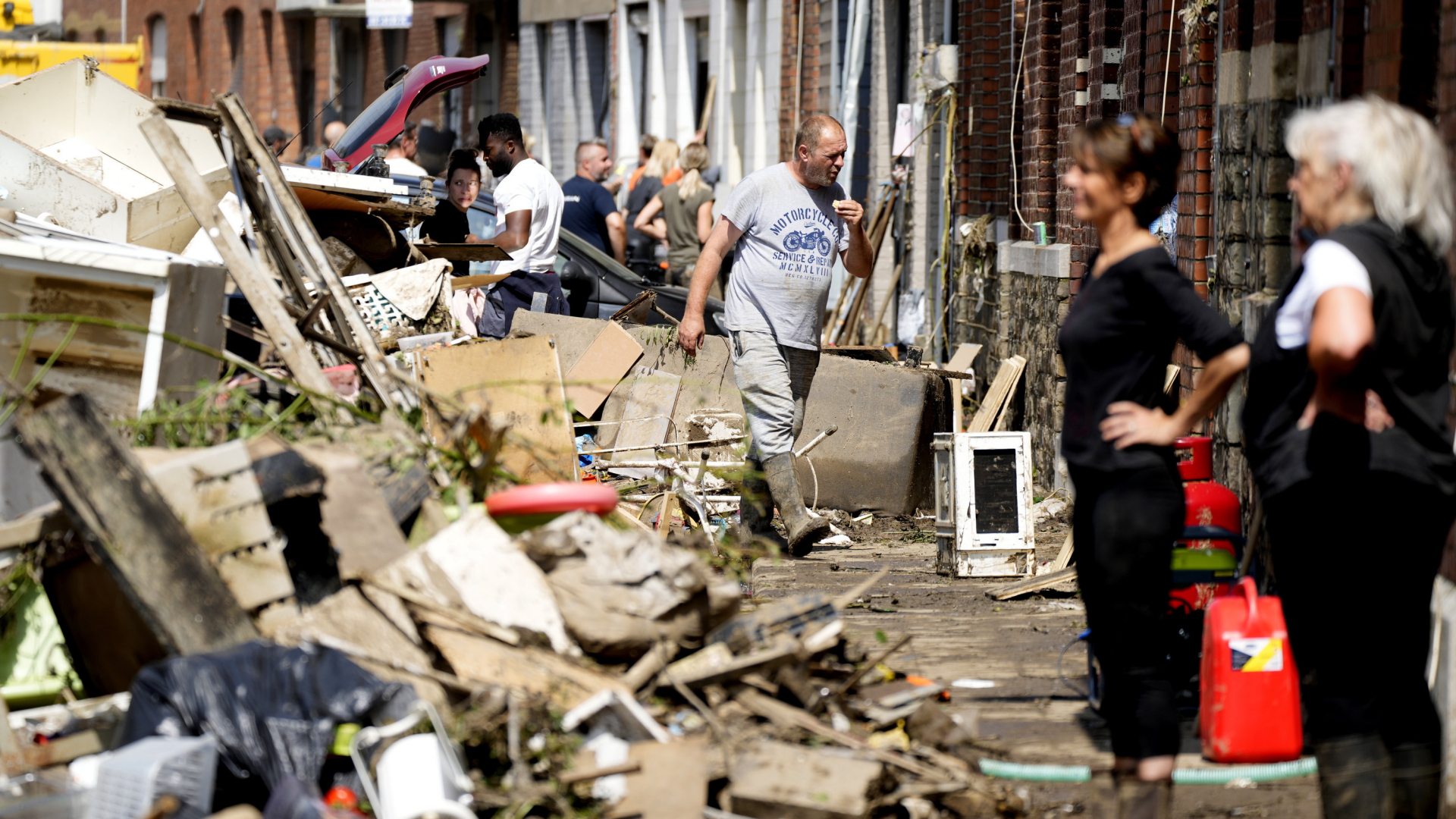 Anwohnerinnen und Anwohner stapeln vom Hochwasser zerstörte Habseligkeiten auf Müllhaufen in Drolenvol, Belgien. | AP