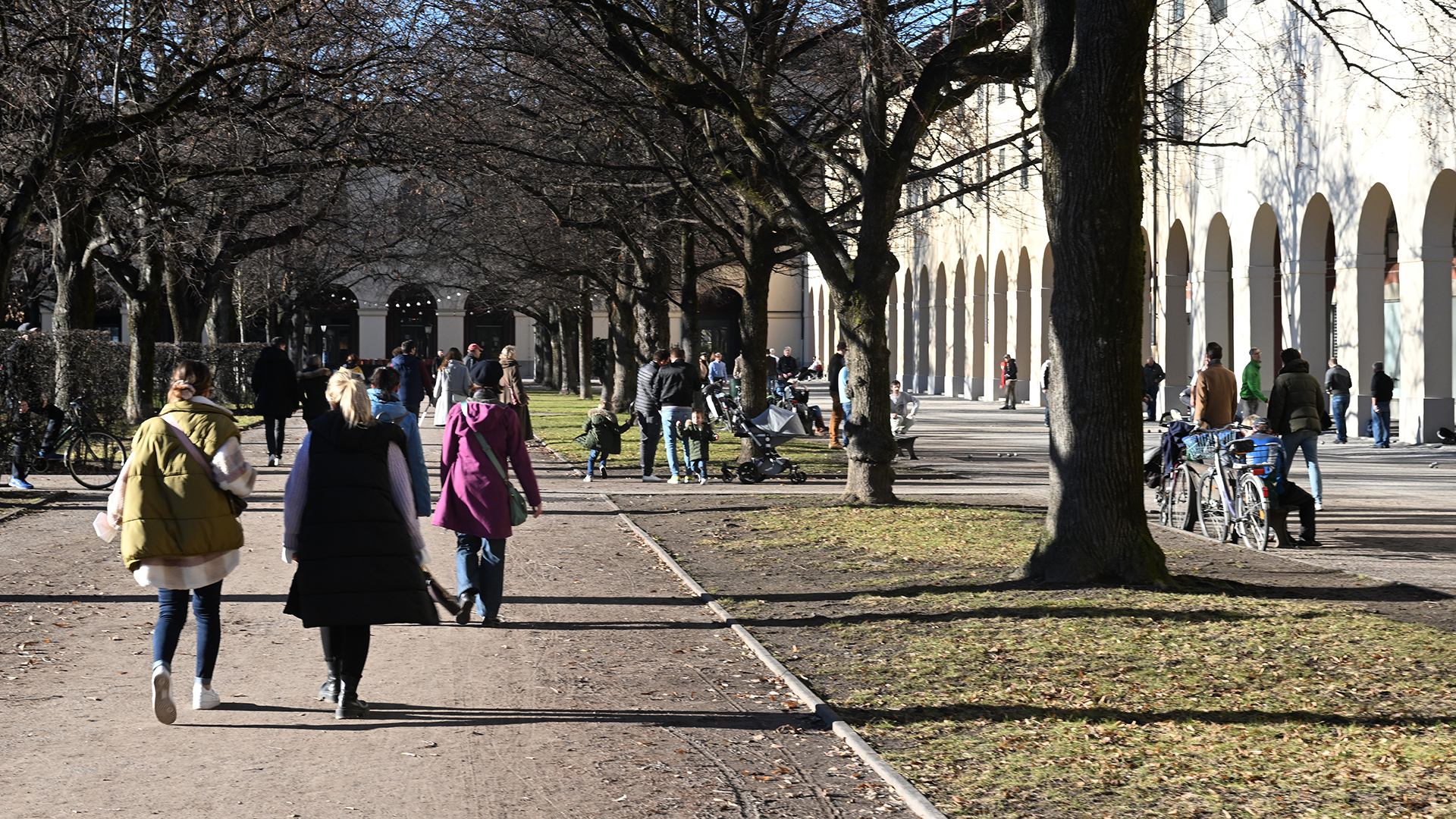 Menschen gehen im Hofgarten in München spazieren. | dpa
