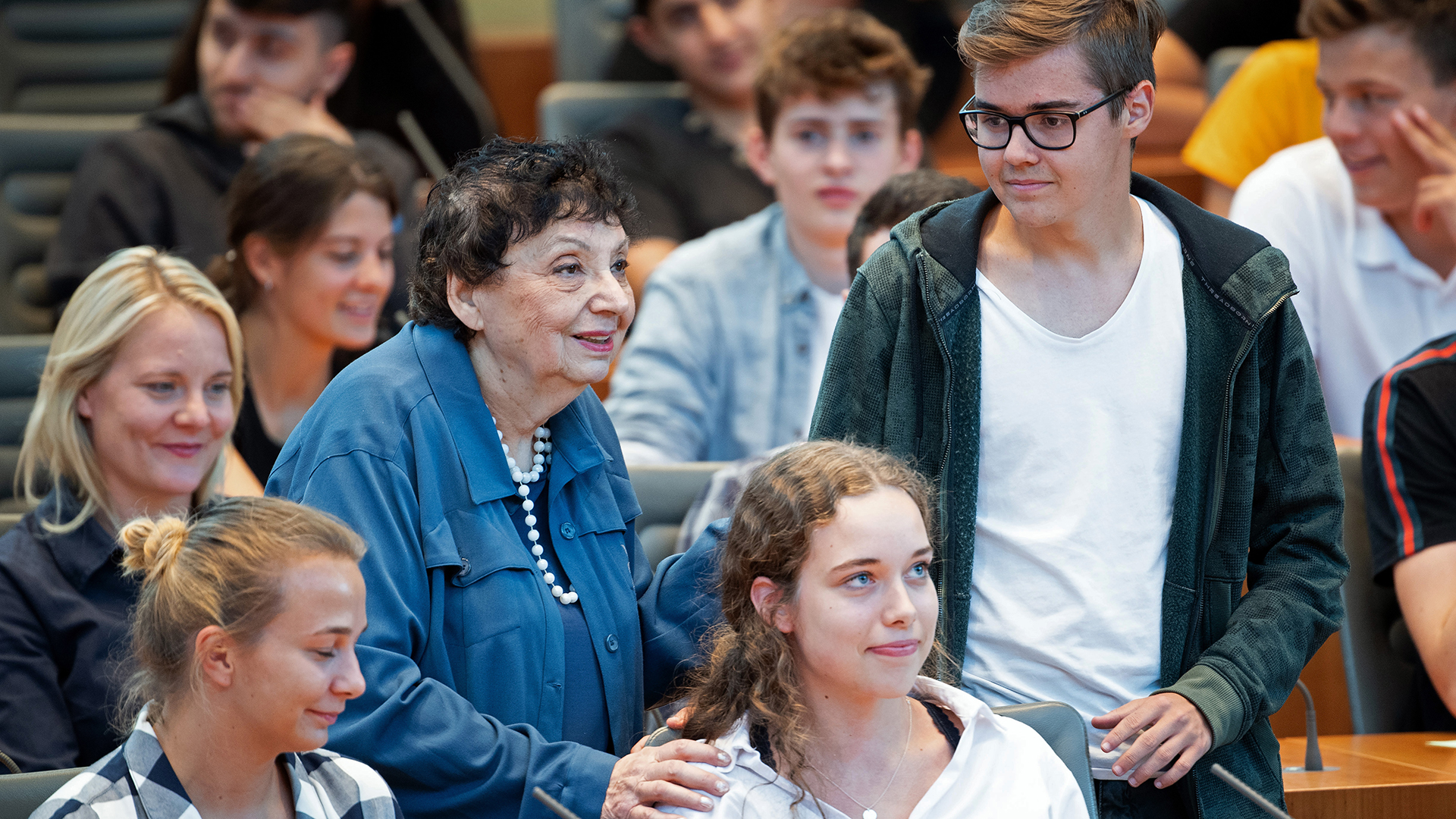 Inge Auerbacher, Holocaust-Überlebende, steht zwischen Jugendlichen im NRW-Landtag und spricht während eines Zeitzeugen-Gesprächs mit etwa 100 Jugendlichen. | picture alliance/dpa