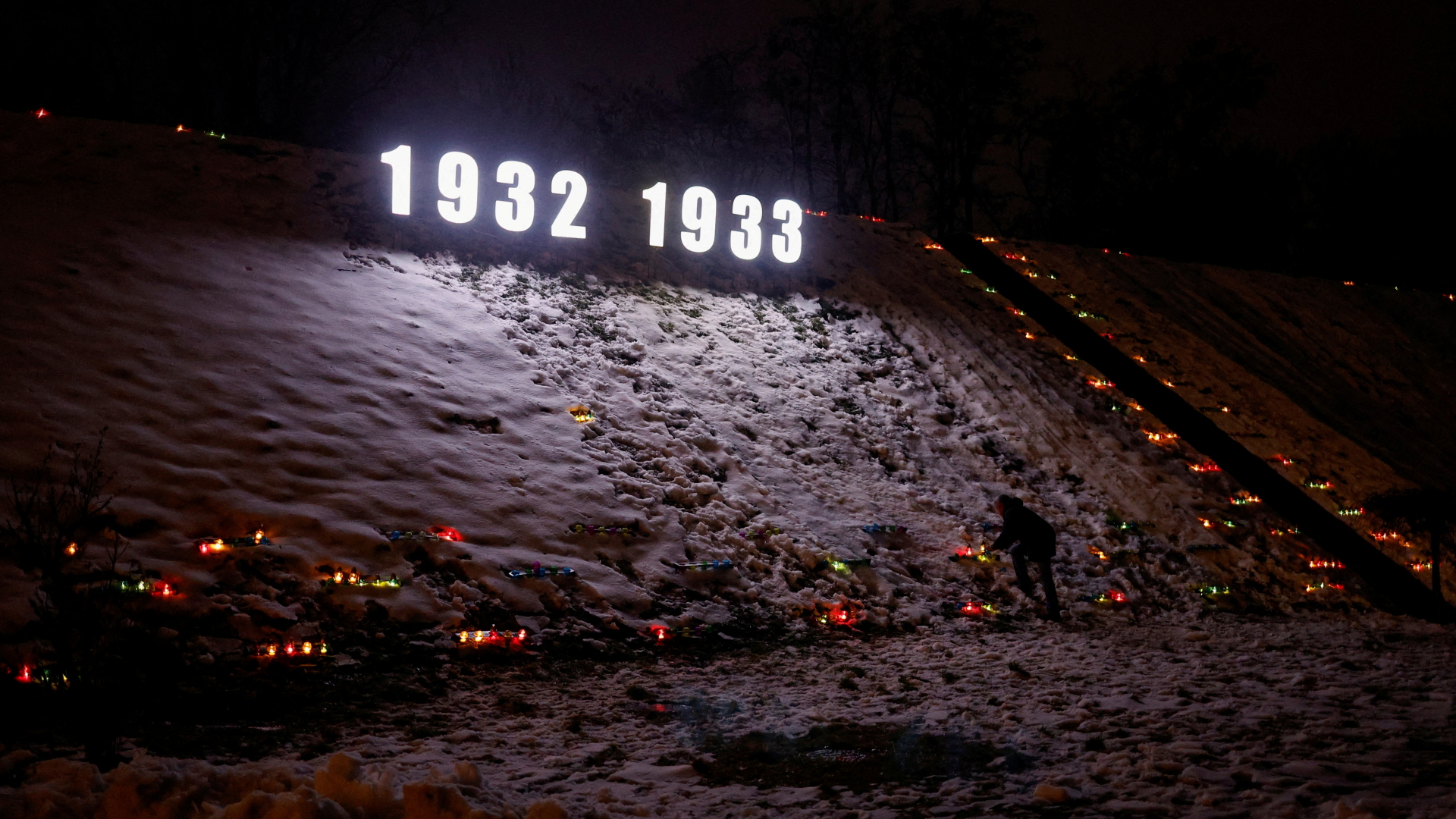 Ein Mann zündet während des Gedenkens am 26. November 2022 am Holodomor-Mahnmal in Kiew eine Kerze an. | REUTERS
