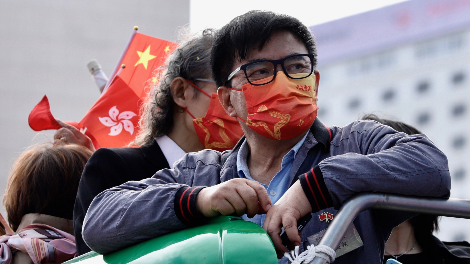"Gemeinsam Hongkong aufbauen" steht auf der Maske eines Mannes, der einen peking-nahen Kurs unterstützt. | dpa