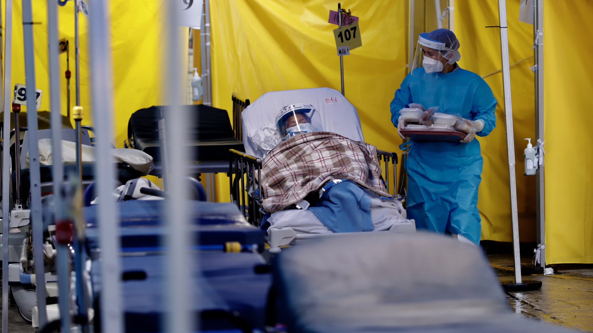 Patienten liegen auf Krankenbetten im provisorischen Wartebereich eines Krankenhauses.  | dpa