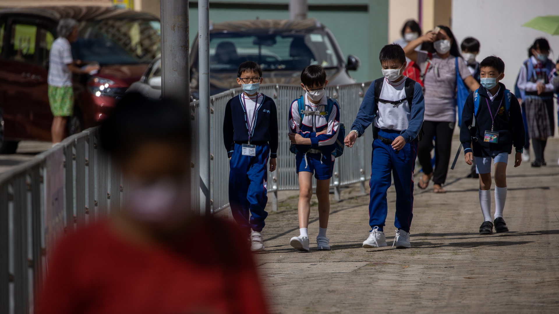 Schüler laufen in Hongkong einen Bürgersteig entlang (Archivbild). | JEROME FAVRE/EPA-EFE/Shutterstoc