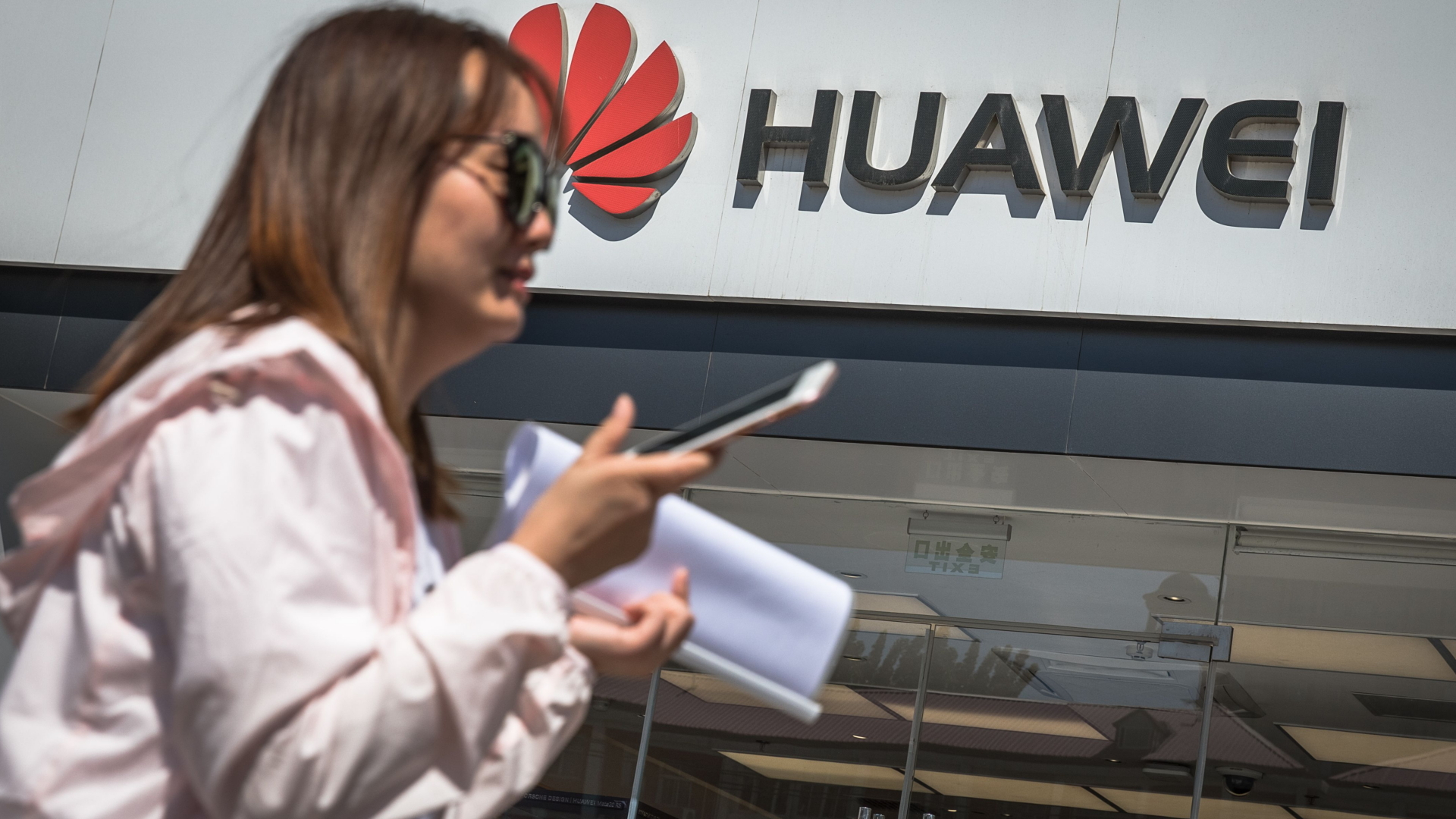 Frau mit Smartphone vor Huawei-Geschäft | ROMAN PILIPEY/EPA-EFE/REX
