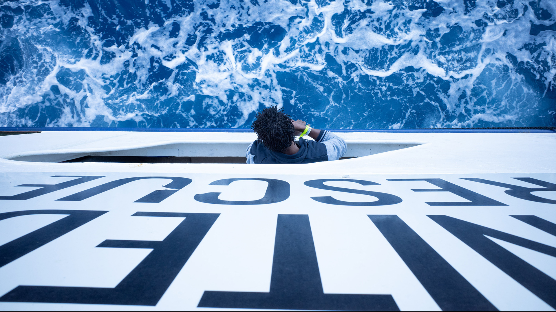 Ein Mann schaut von einem Schiff ins Wasser. | picture alliance/dpa/SOS Humanit