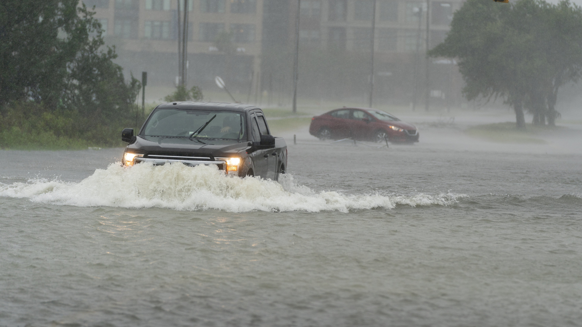 Ein Auto fährt in Charleston, South Carolina, über eine überschwemmte Straße. | AP