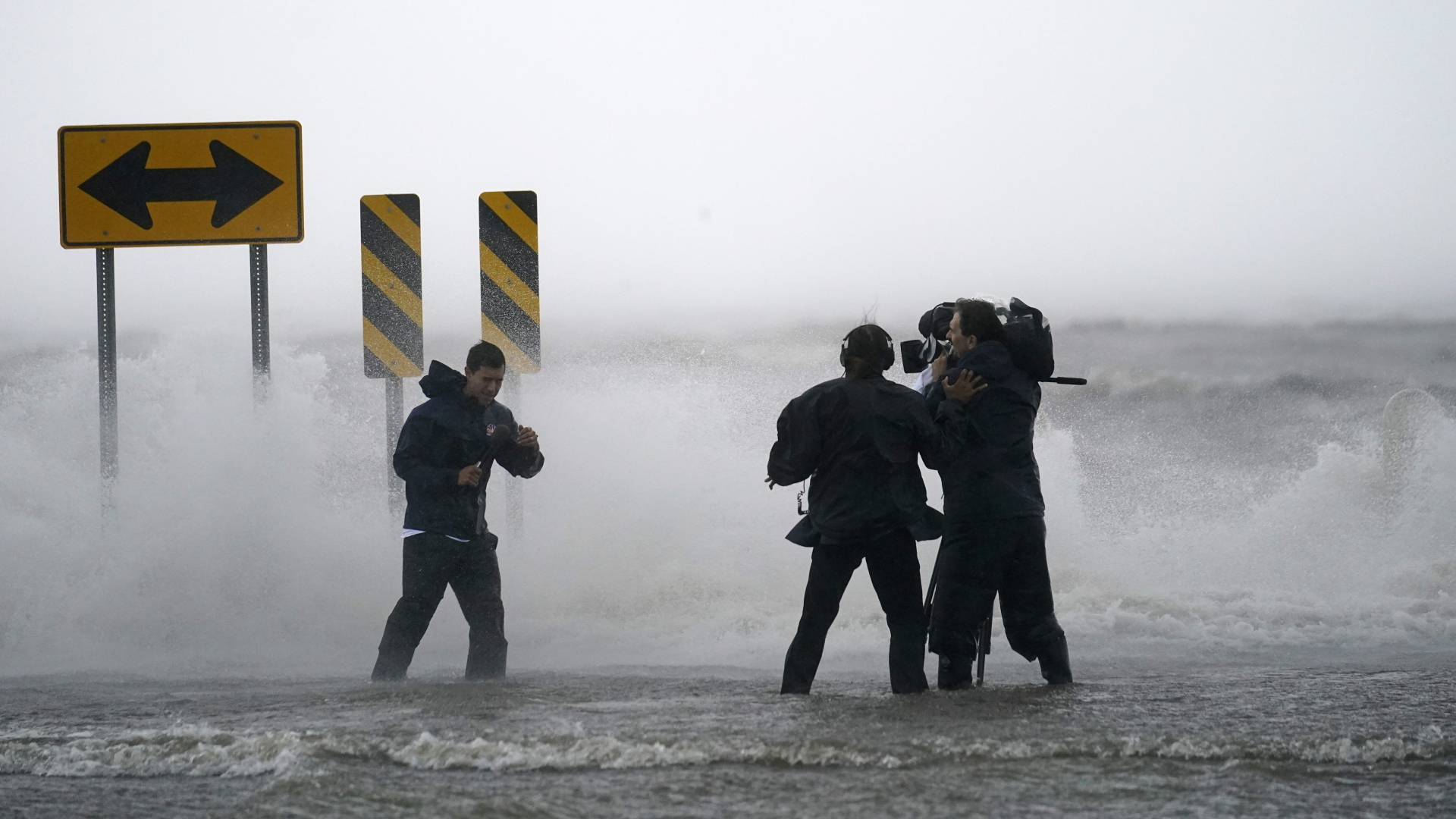 Ein Nachrichtenteam steht im Wasser des Lake Pontchartrains im US-Bundesstaat Louisiana