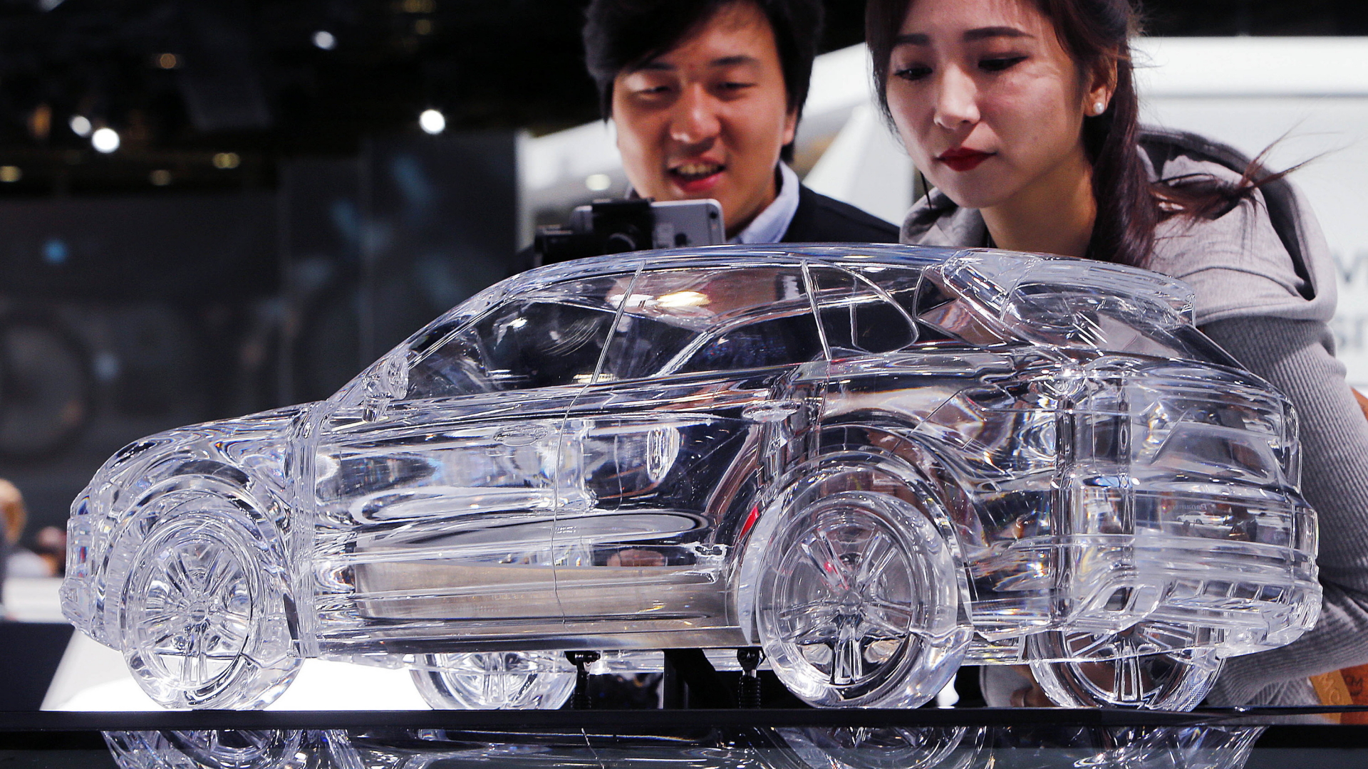 Asiatische Besucher schauen auf ein Modell des Porsche Cayenne | AP