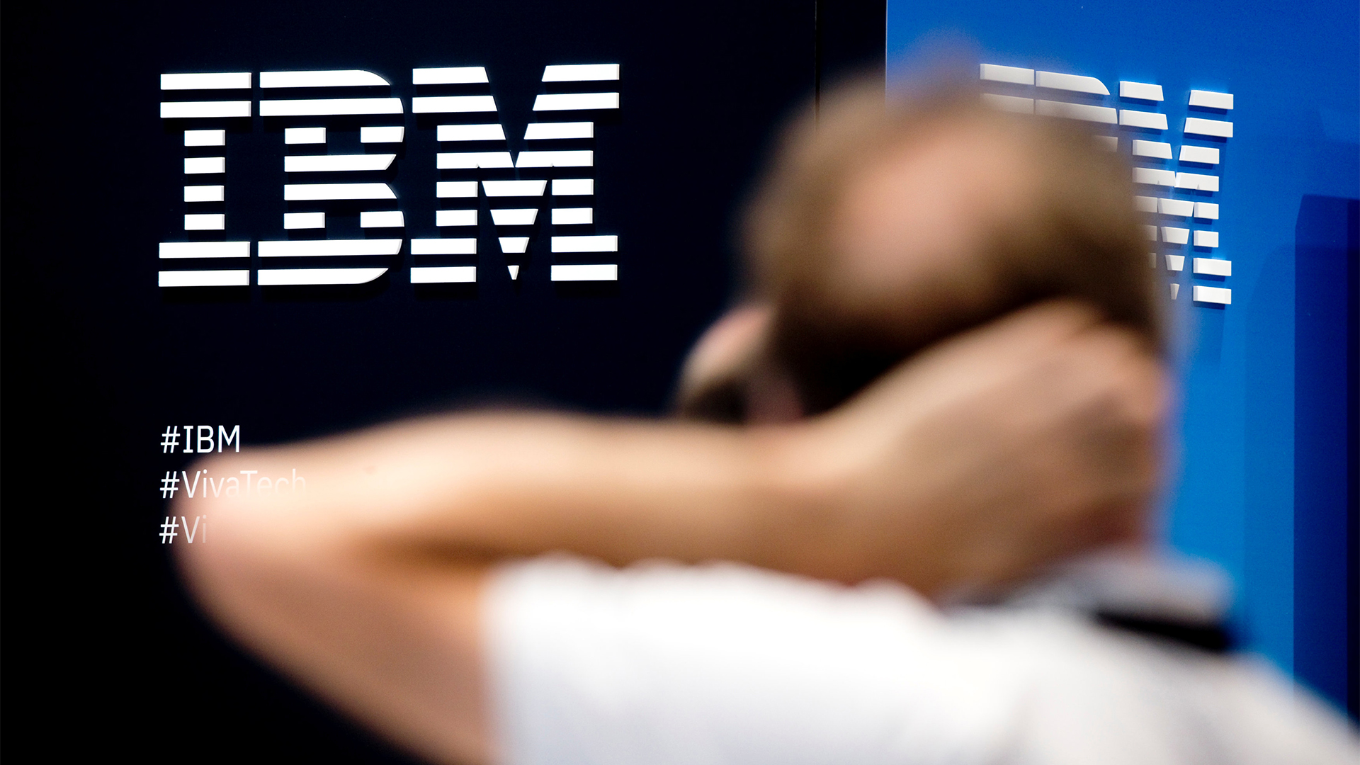 Ein Mann steht vor dem Logo von IBM | REUTERS